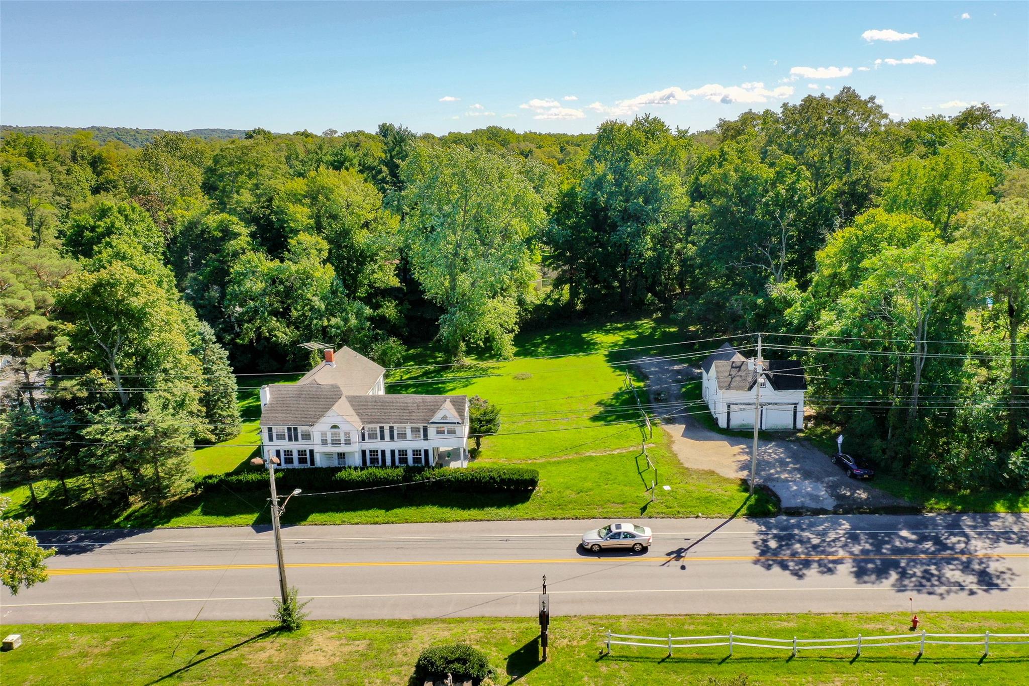 Aerial view of property and surrounding area featuring a forest
