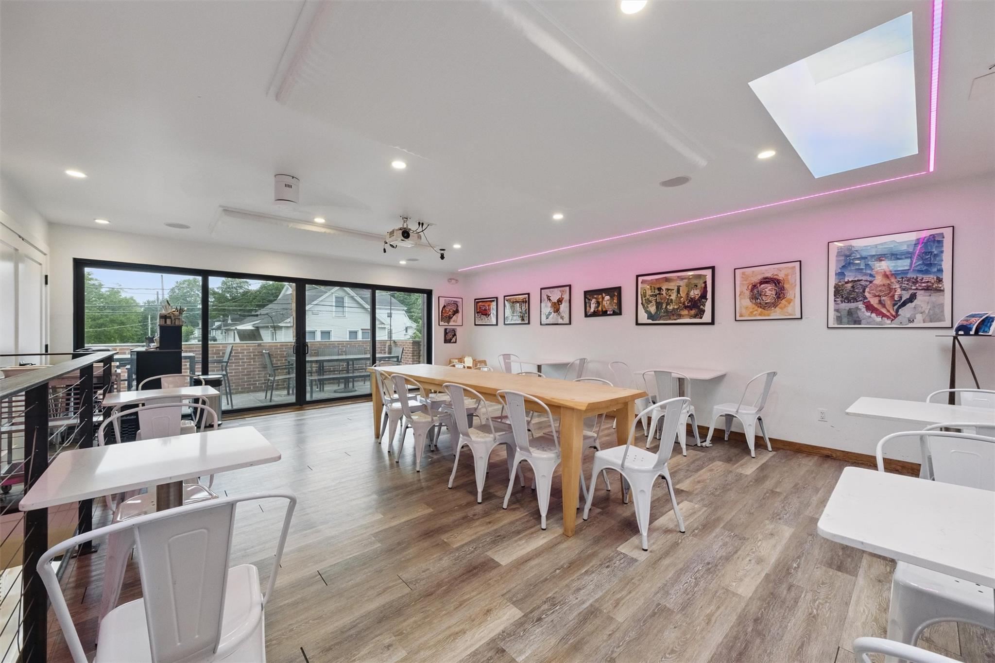 Dining area featuring recessed lighting, light wood finished floors, and a skylight