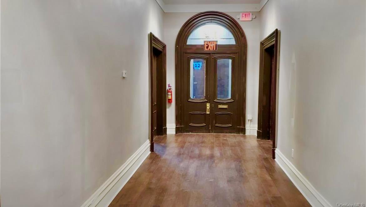 Doorway to outside with wood finished floors and baseboards