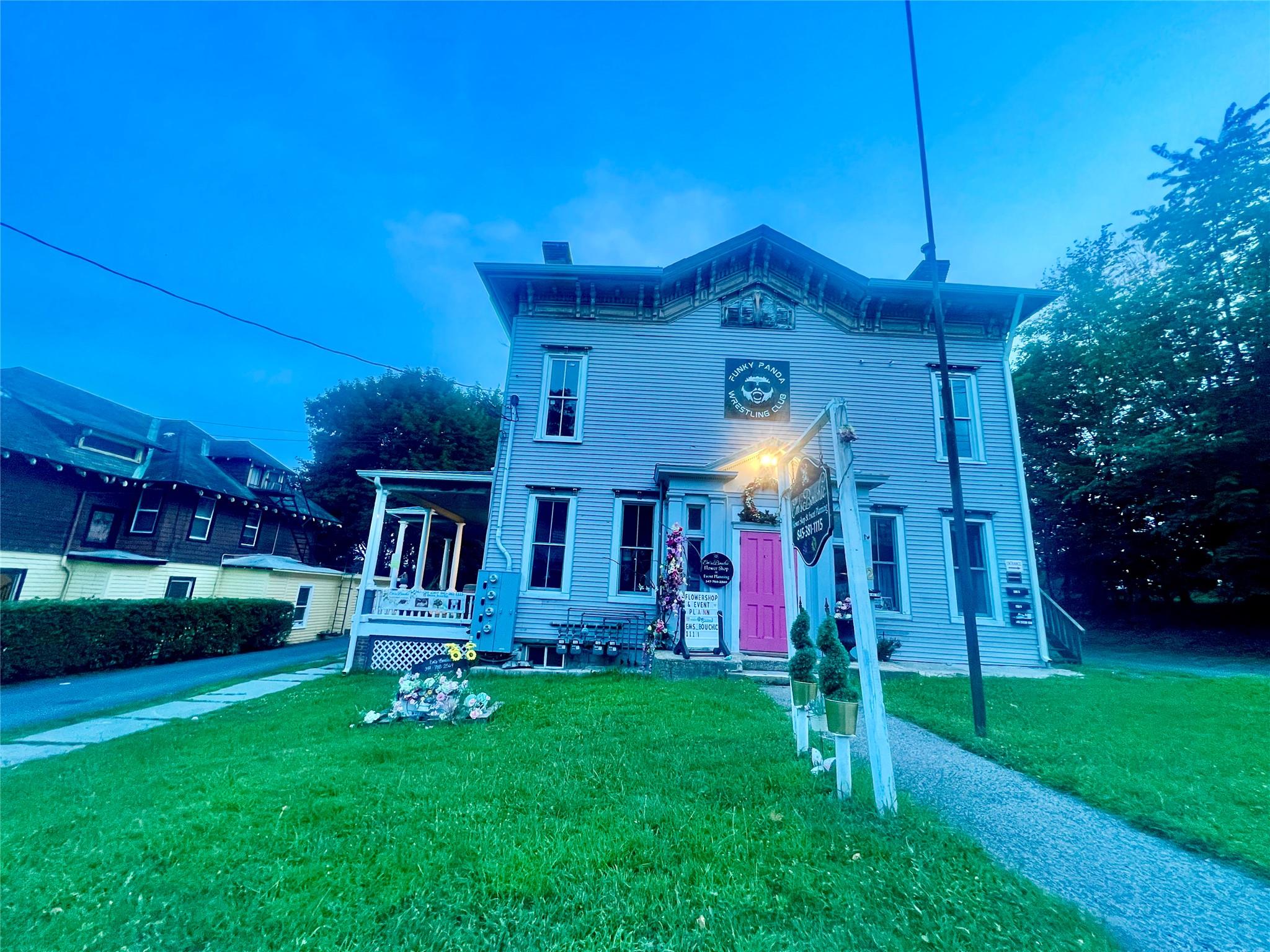 Italianate-style house featuring a chimney and a front yard