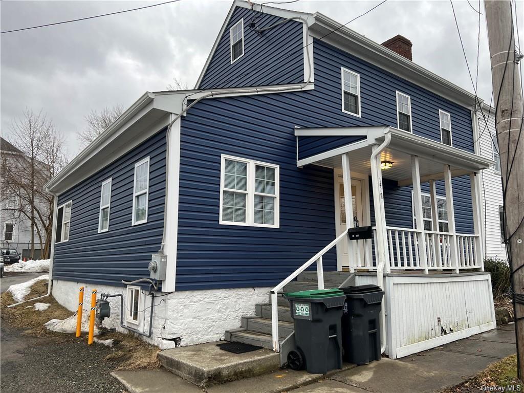 View of front of property featuring a porch and a chimney