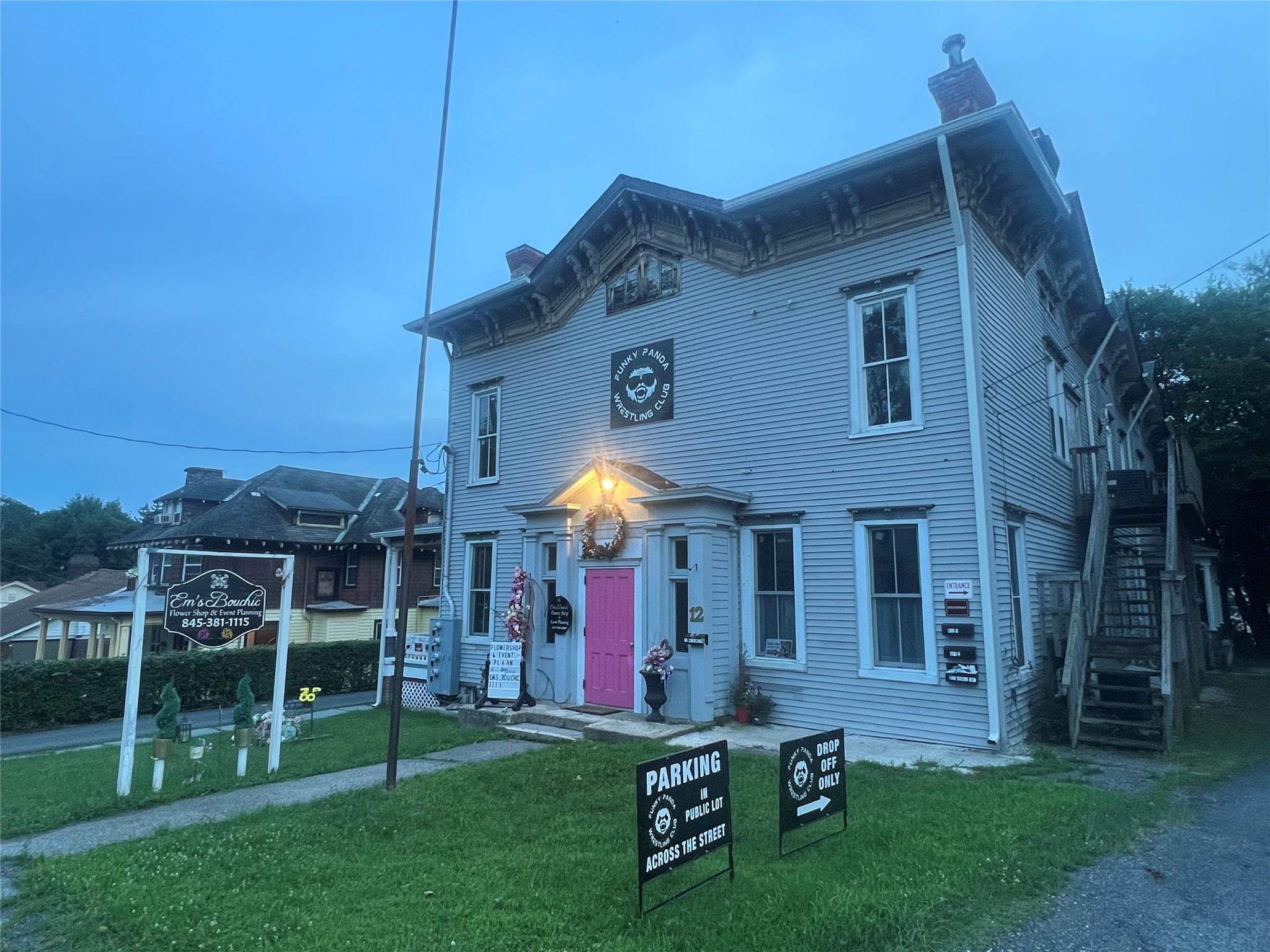 Italianate home featuring a front lawn, a chimney, and stairway