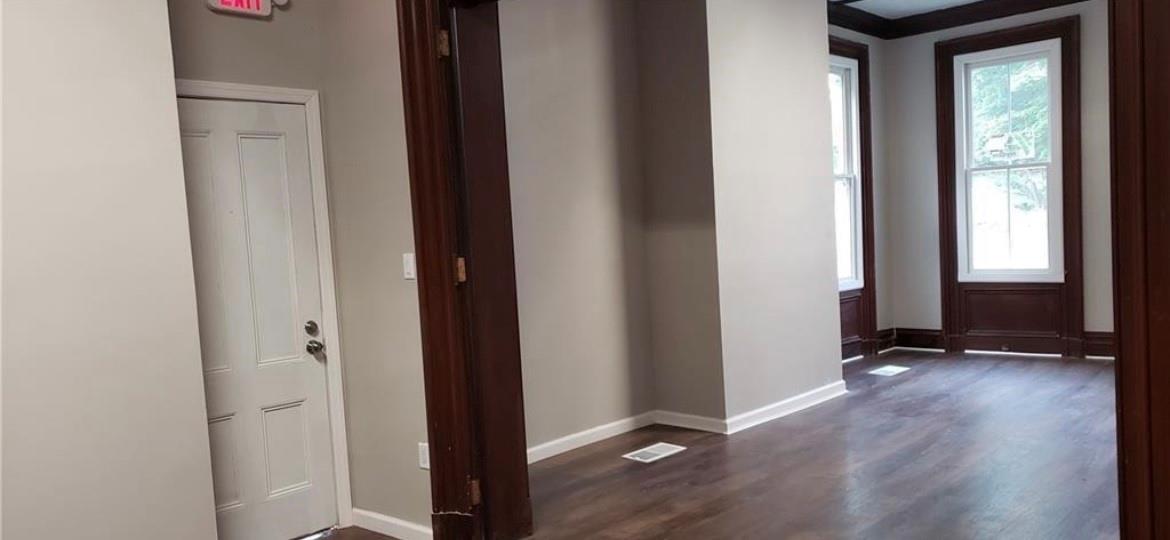 Hallway with dark hardwood / wood-style flooring and ornamental molding