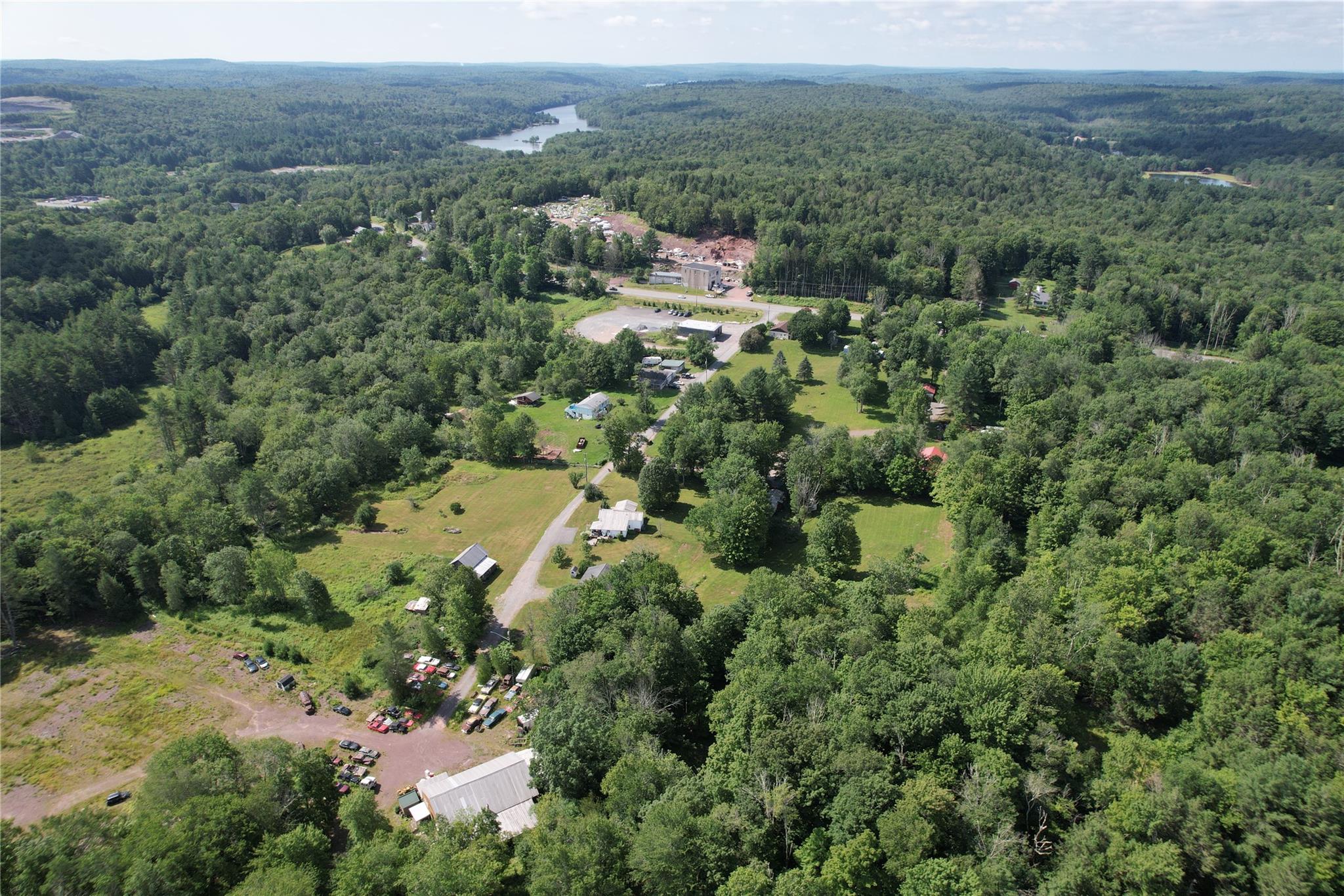 Aerial overview of property's location with a heavily wooded area
