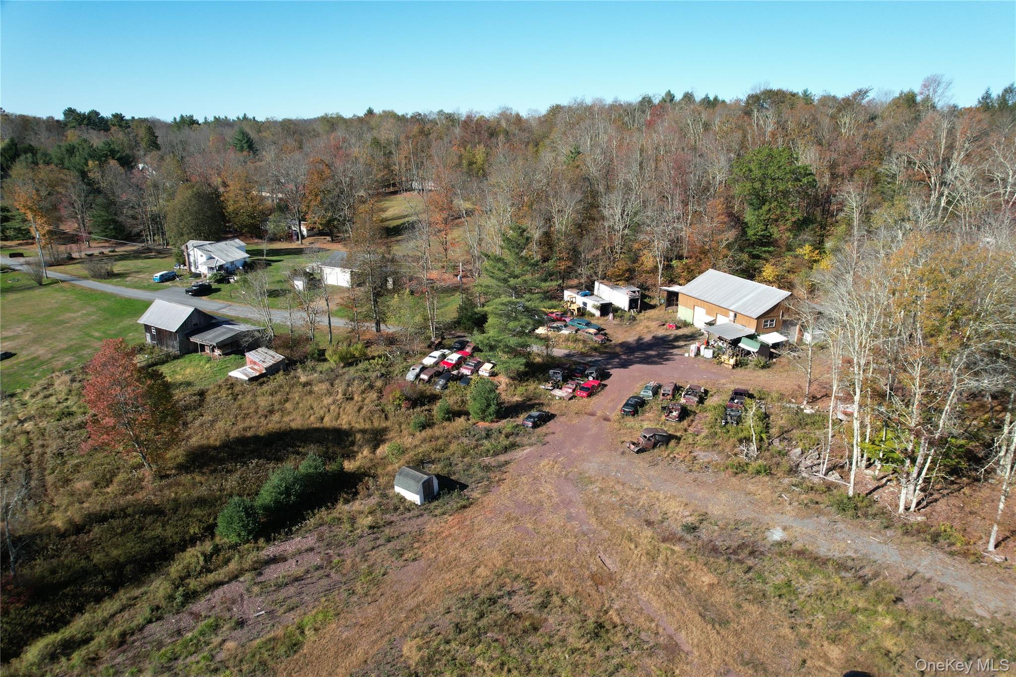 Aerial view of property and surrounding area with a heavily wooded area
