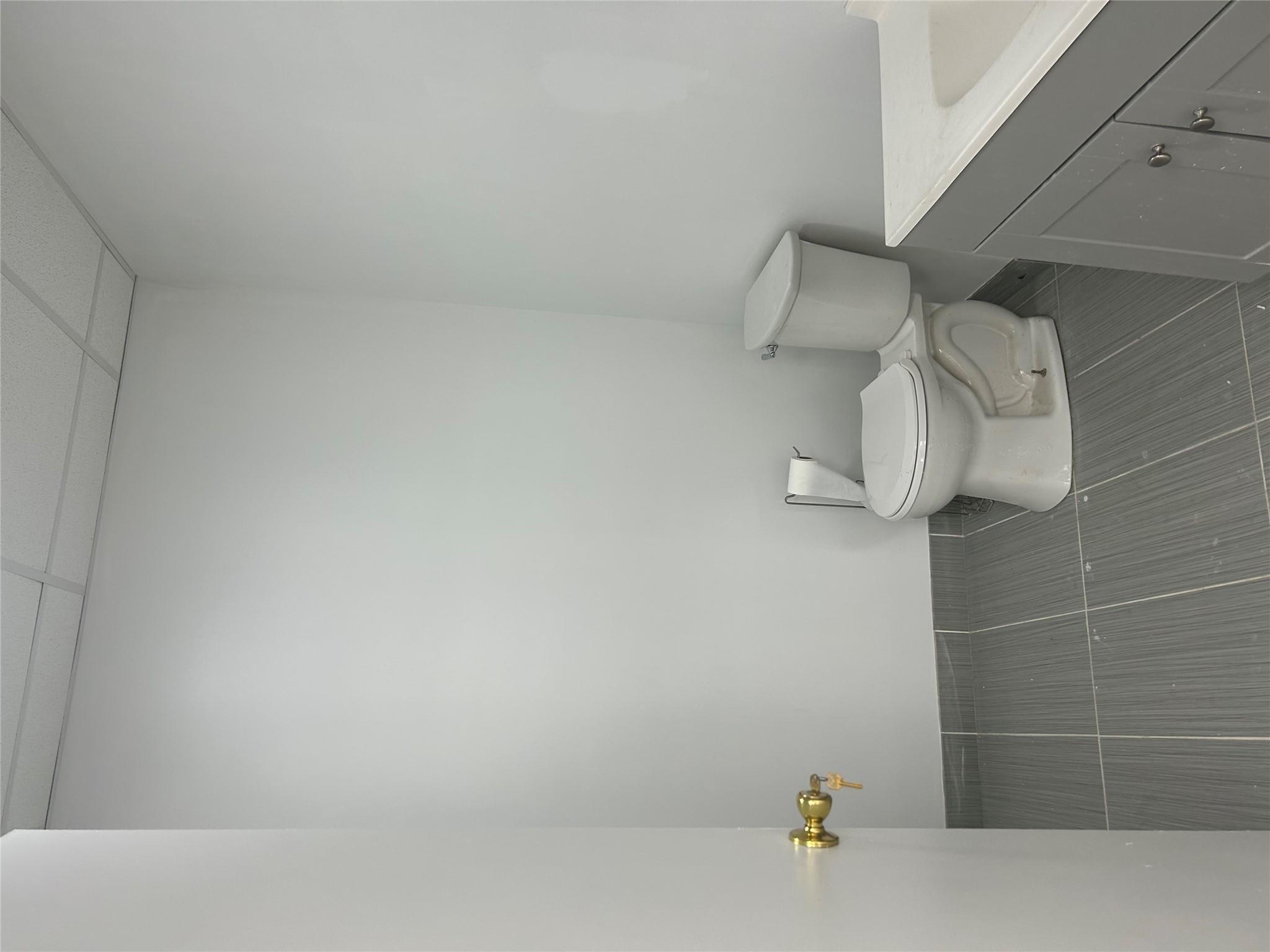 Half bathroom featuring vanity, tile patterned flooring, and a drop ceiling