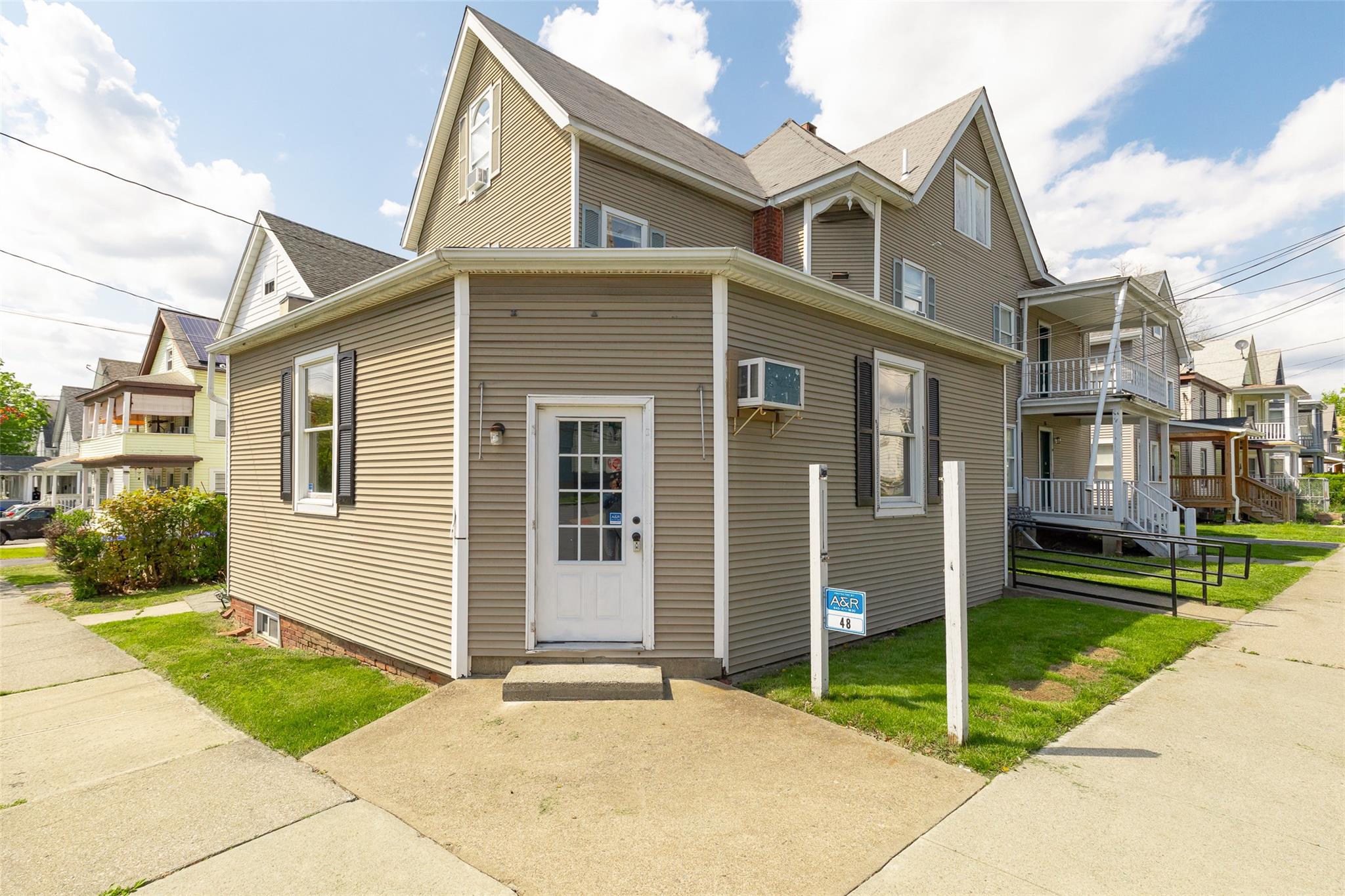 View of front of property featuring a residential view and a wall mounted AC