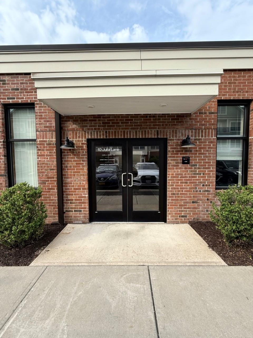 Property entrance with french doors, driveway, and brick siding