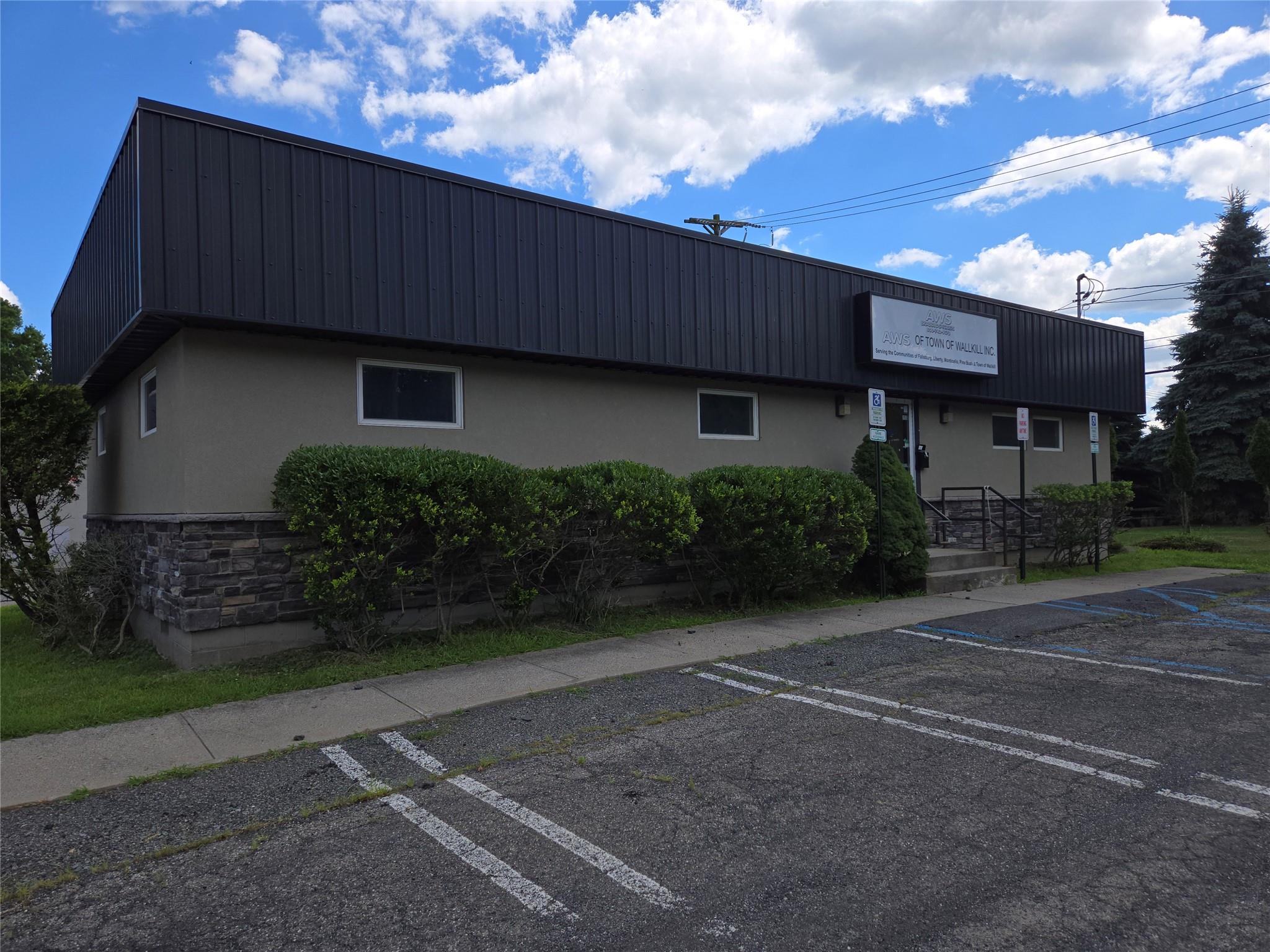 View of building exterior featuring uncovered parking