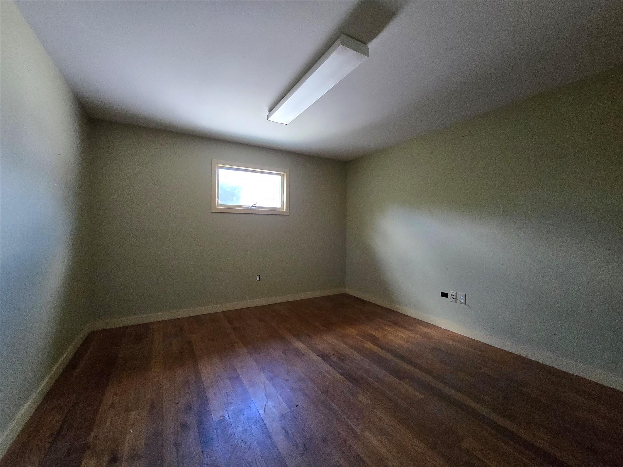 Spare room featuring wood finished floors and baseboards