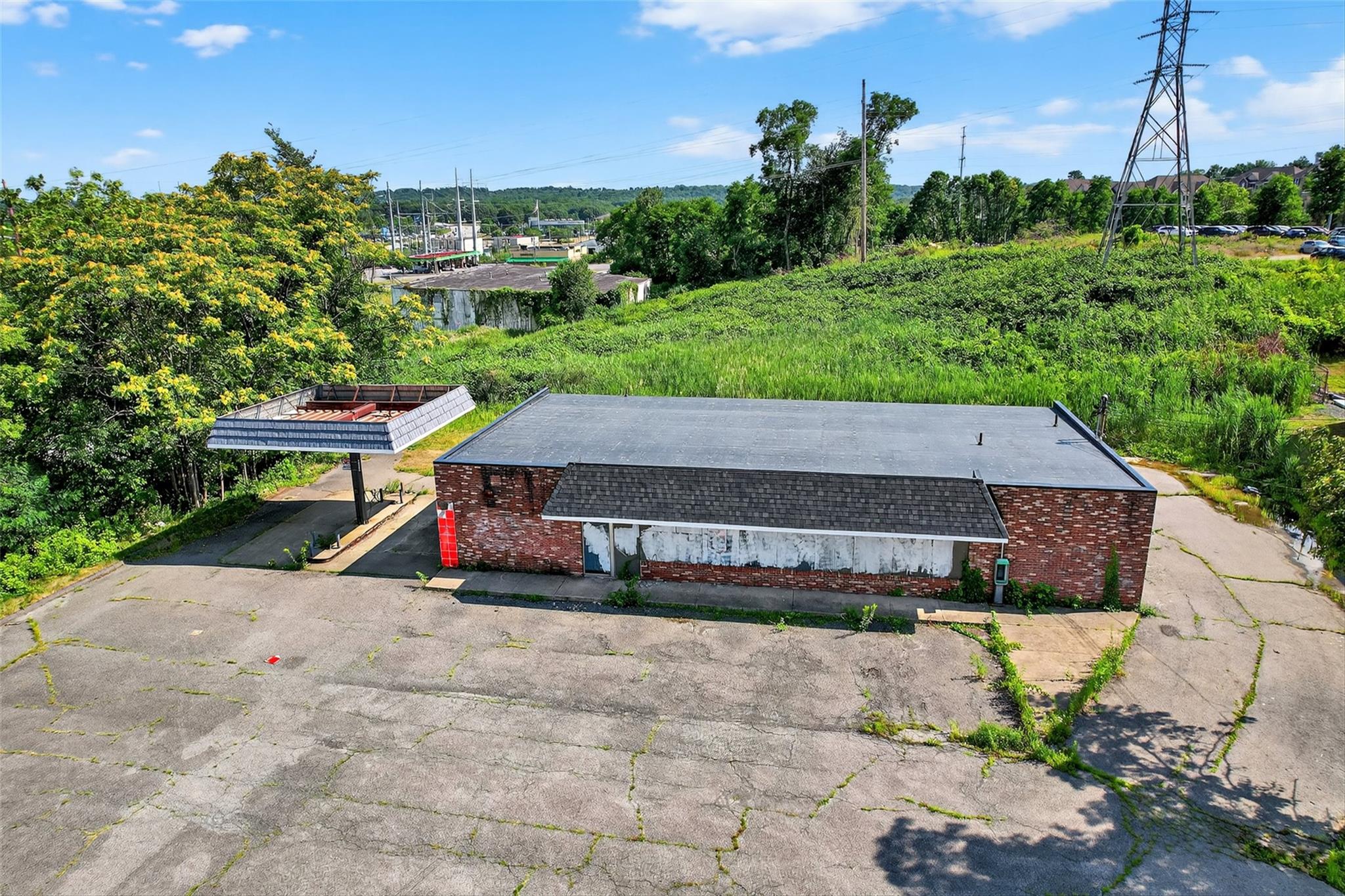View of subject property featuring a tree filled landscape