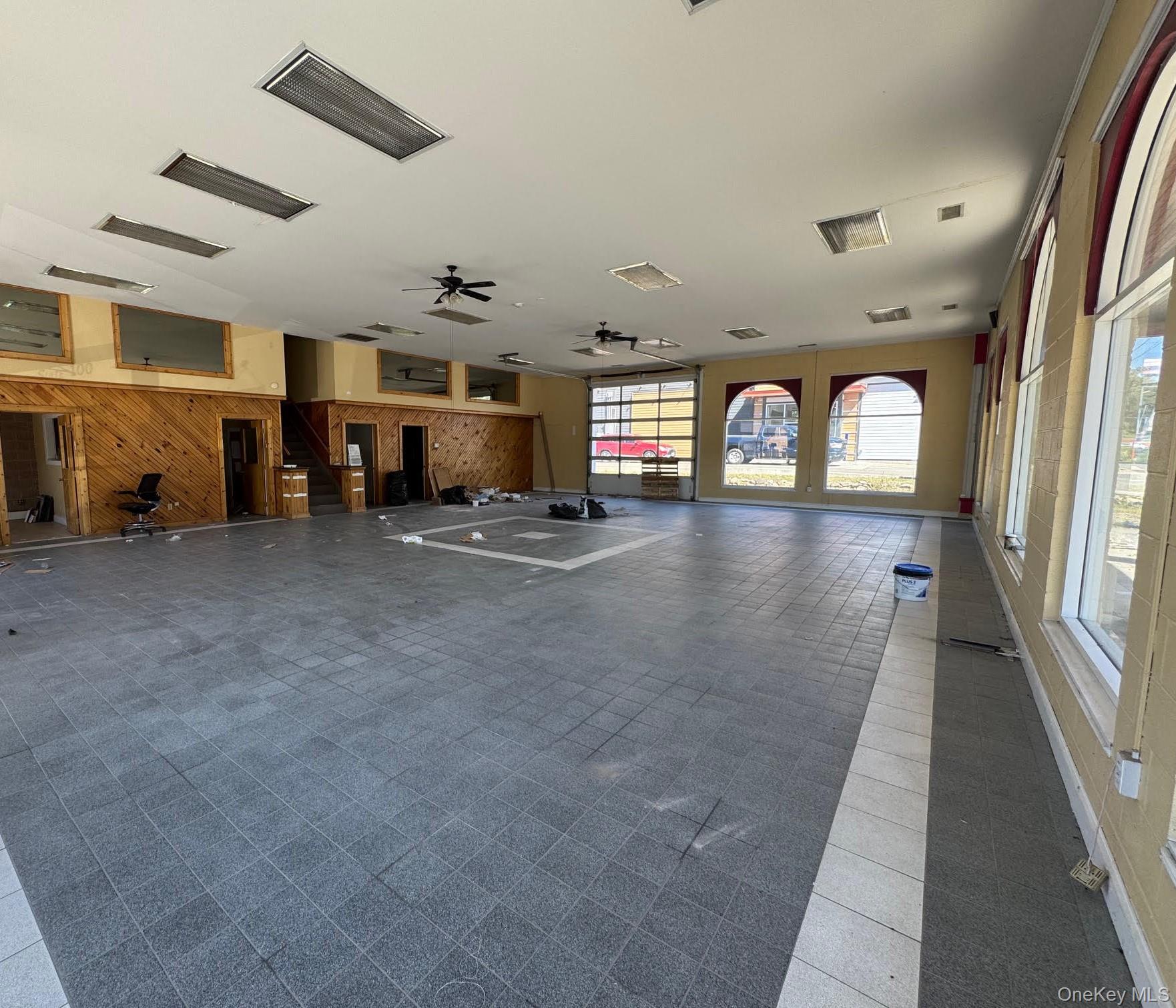 Exercise room featuring wooden walls and ceiling fan