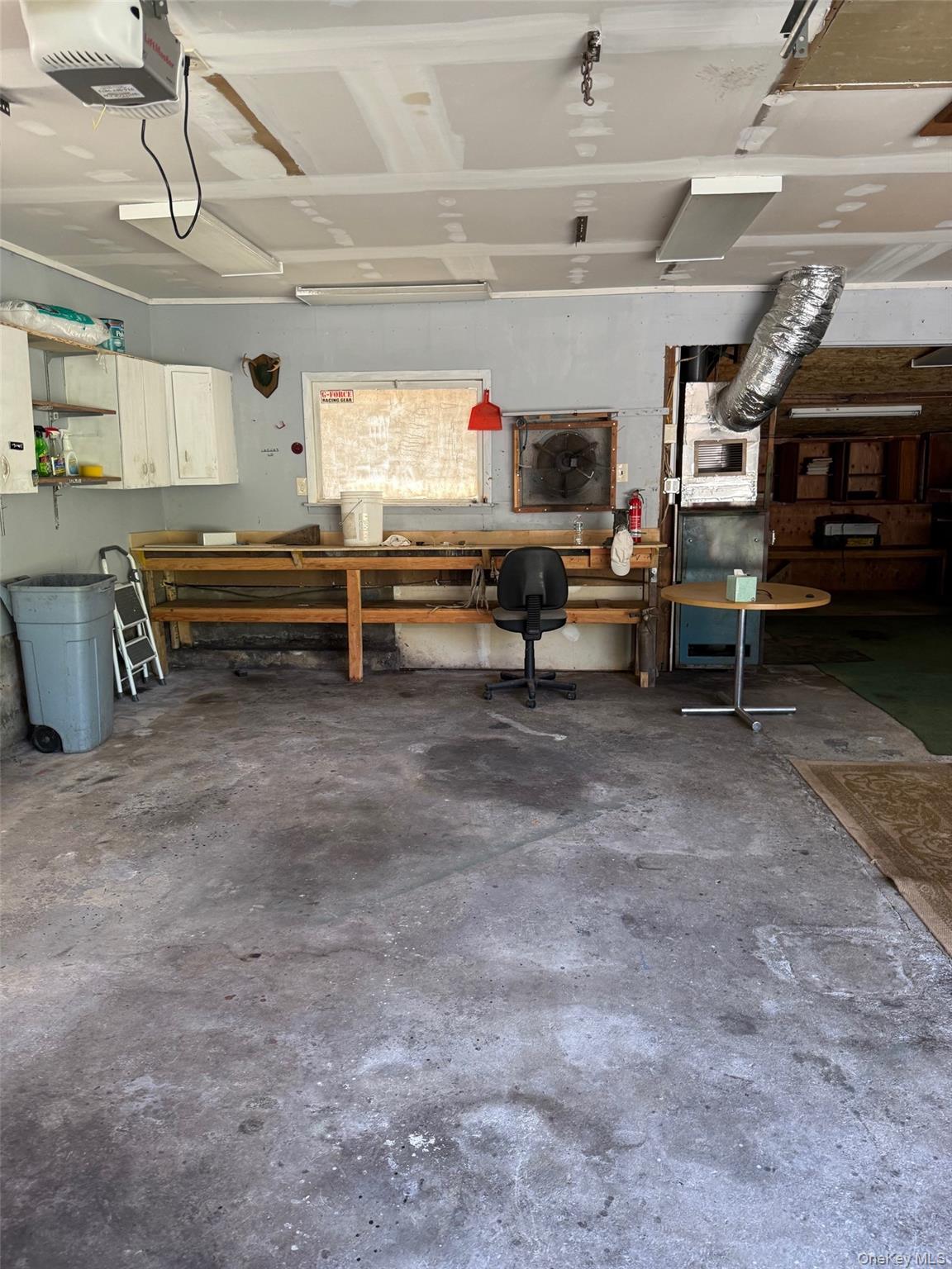 Garage featuring a workshop area and a garage door opener