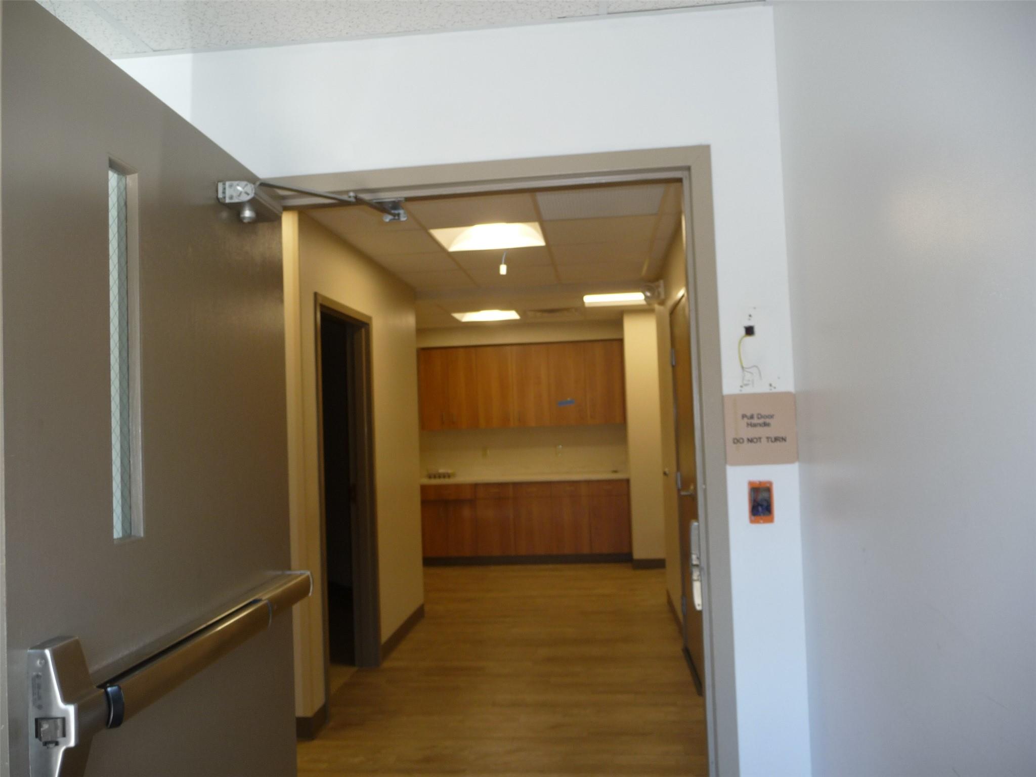 Corridor featuring light wood-style floors and a drop ceiling