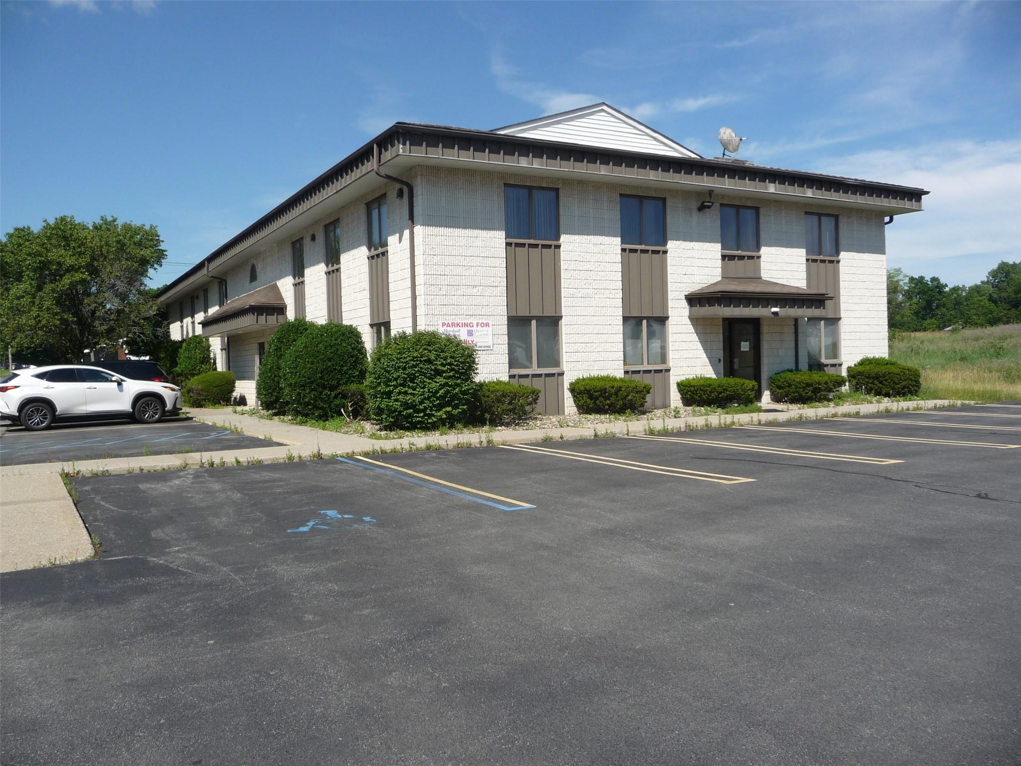 View of property featuring uncovered parking
