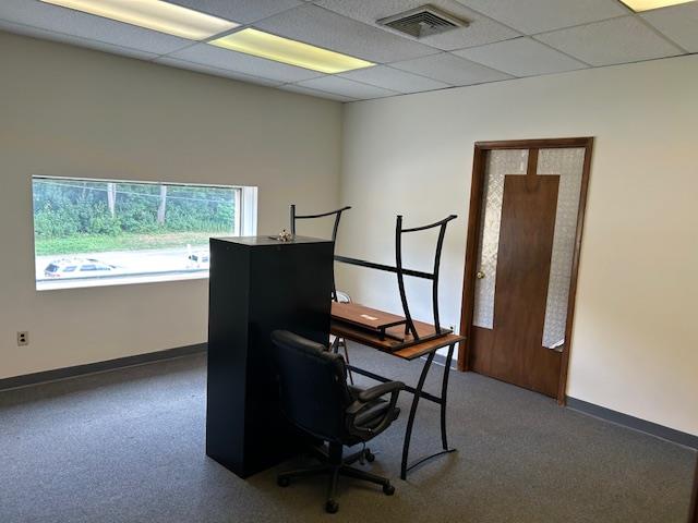Office space with baseboards and a drop ceiling
