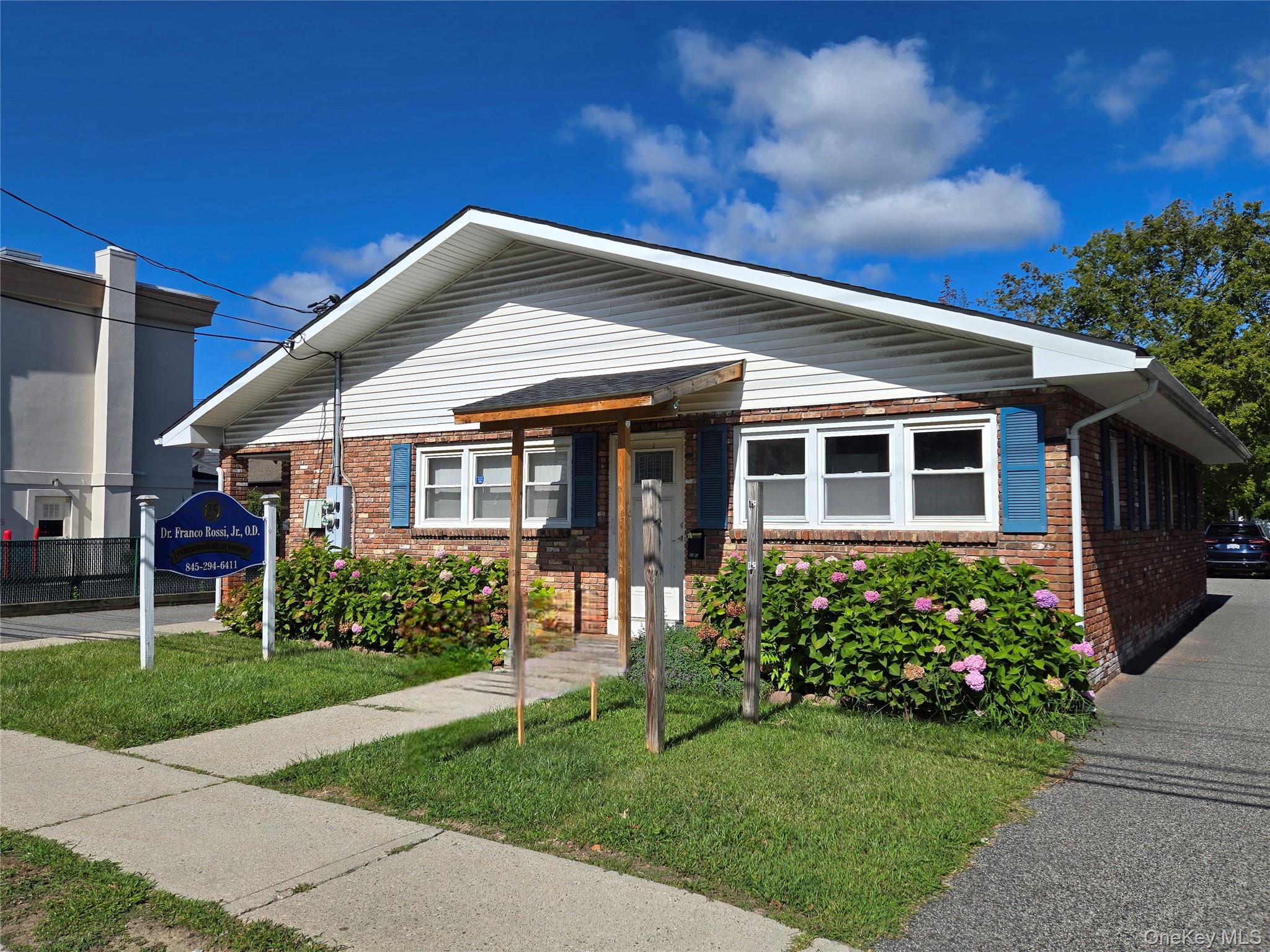 View of front of home featuring brick siding and a front yard