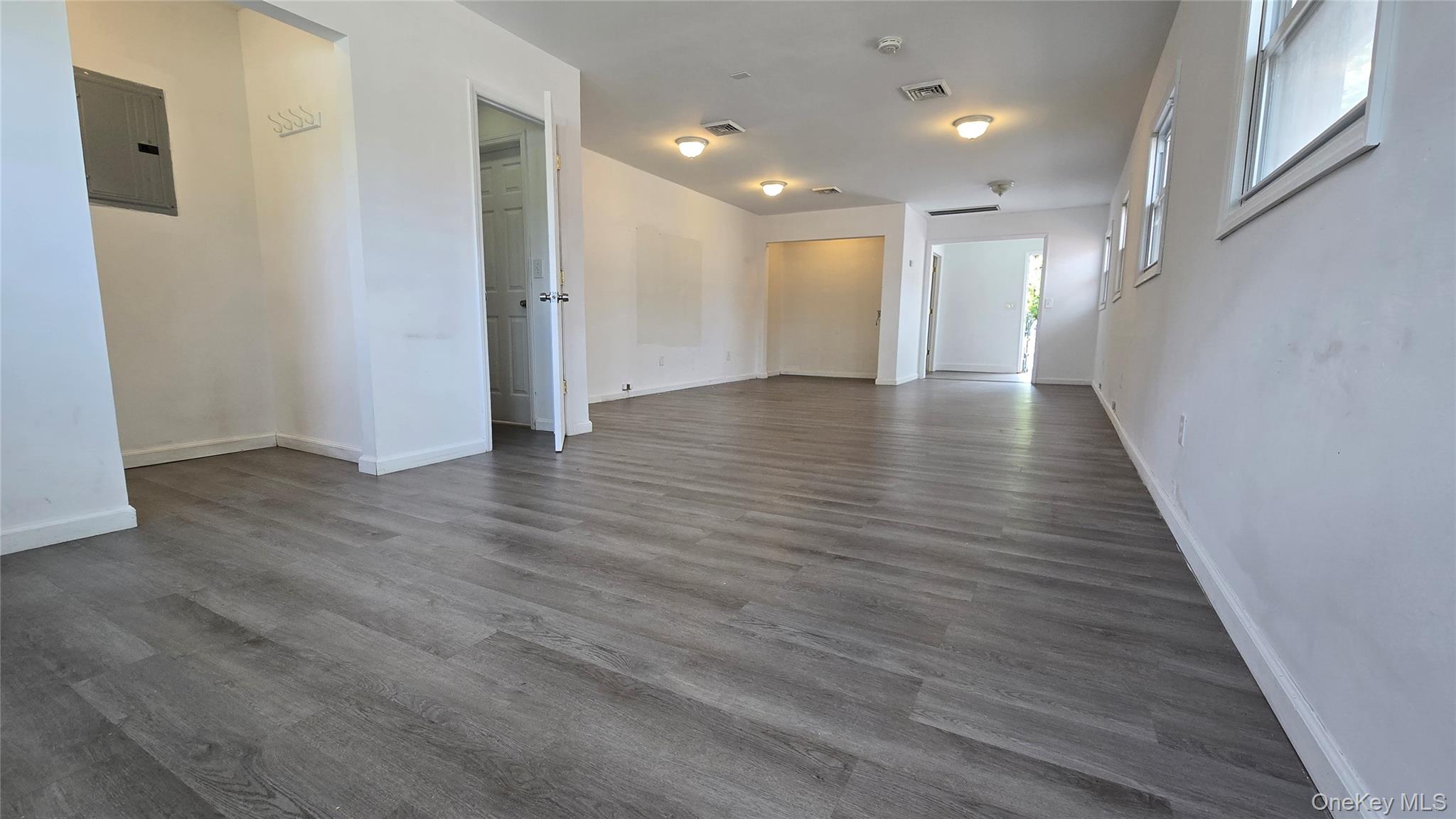 Spare room featuring dark wood finished floors and electric panel