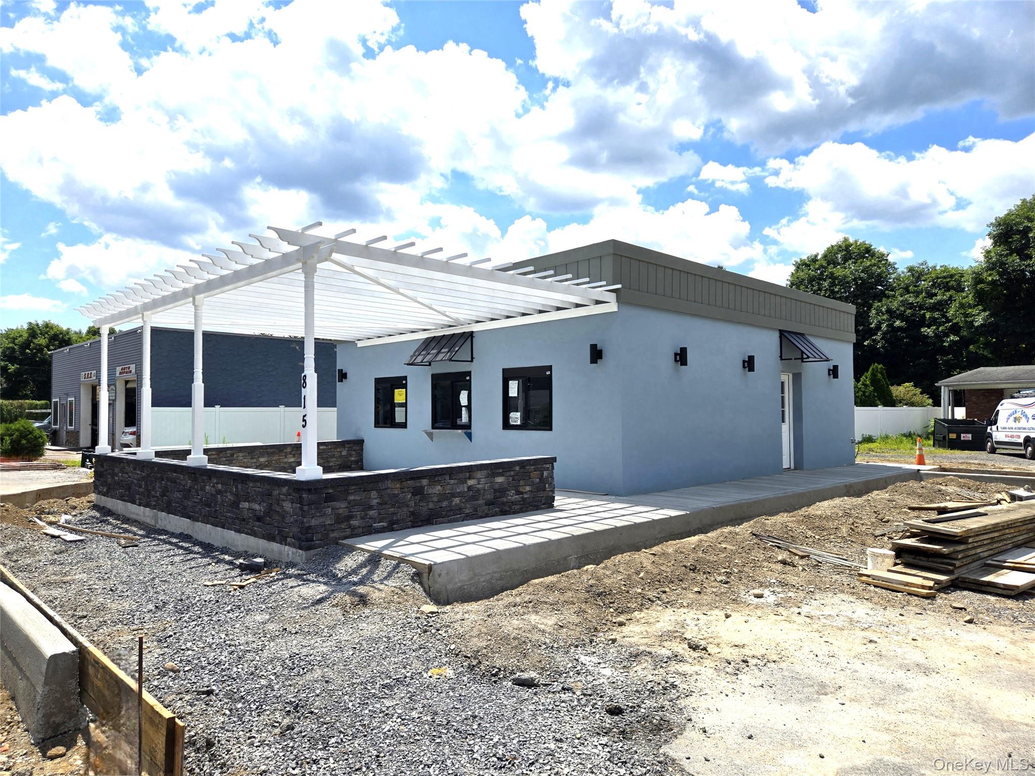 View of home's exterior with stucco siding and a pergola