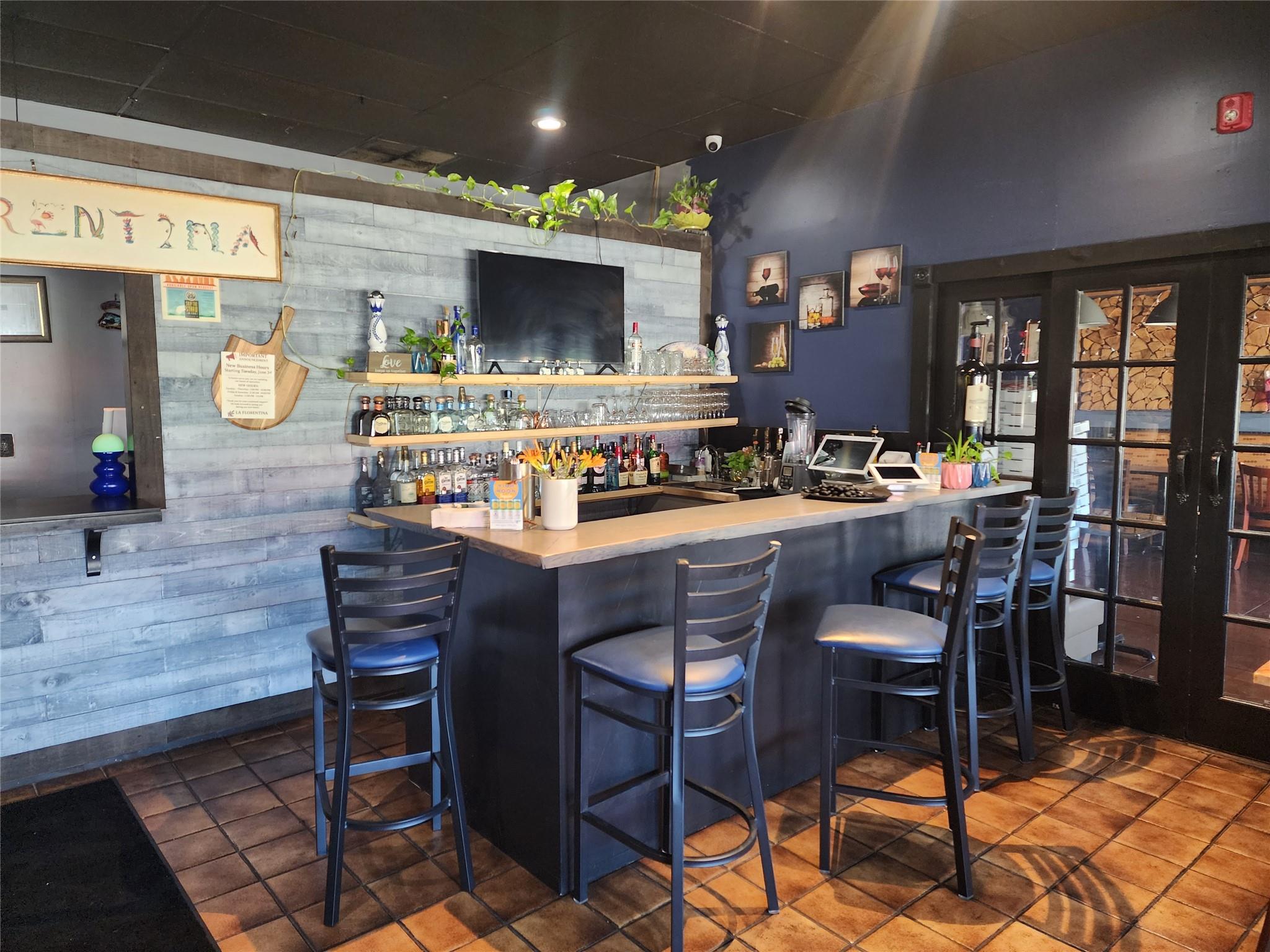 Community bar area with recessed lighting and tile patterned floors