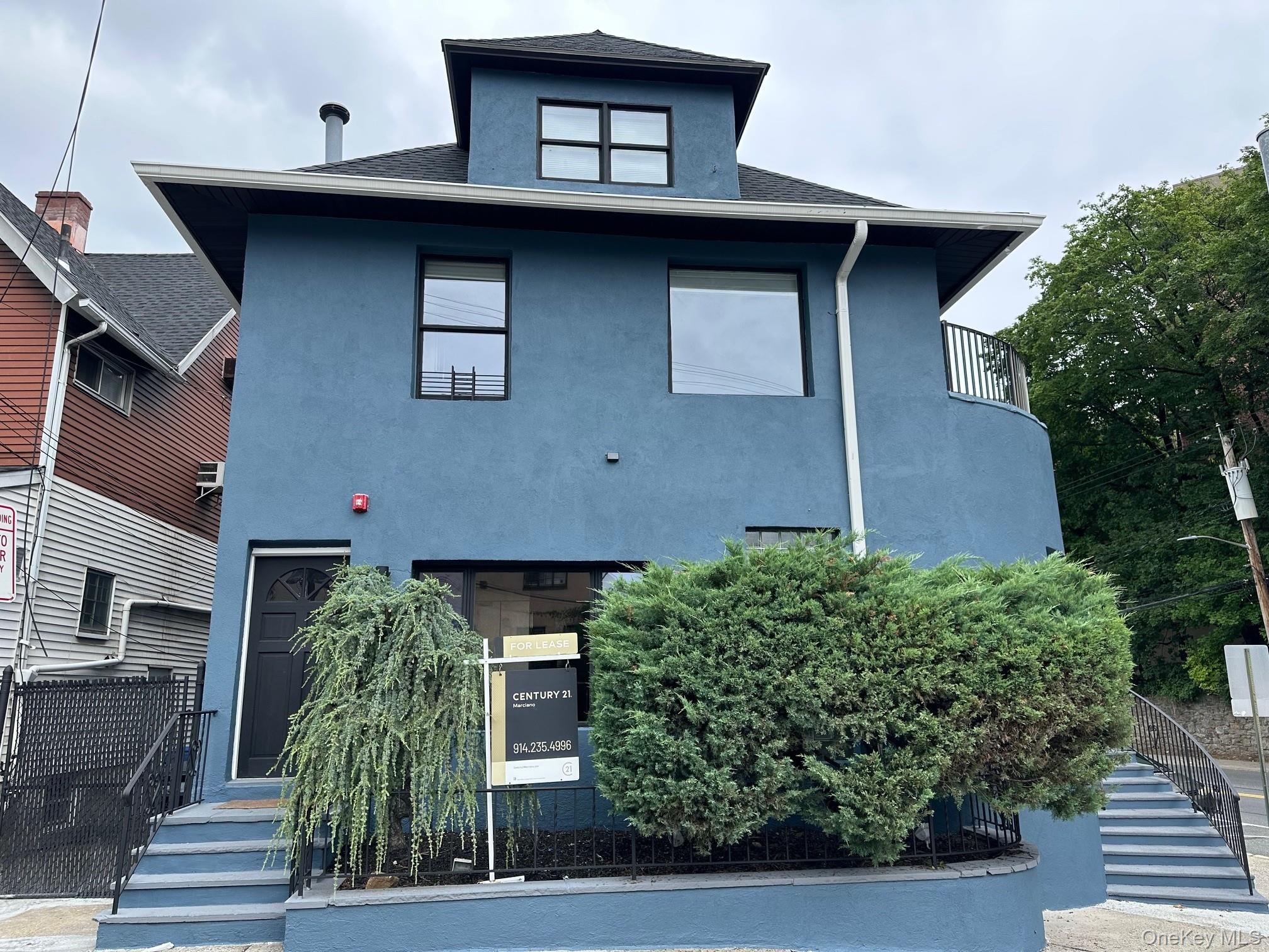 View of front of house featuring stucco siding, stairway, a balcony, and a shingled roof