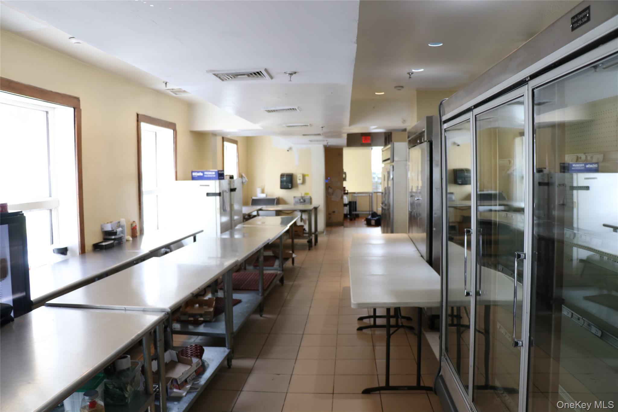Kitchen featuring fridge, tile patterned flooring, and recessed lighting
