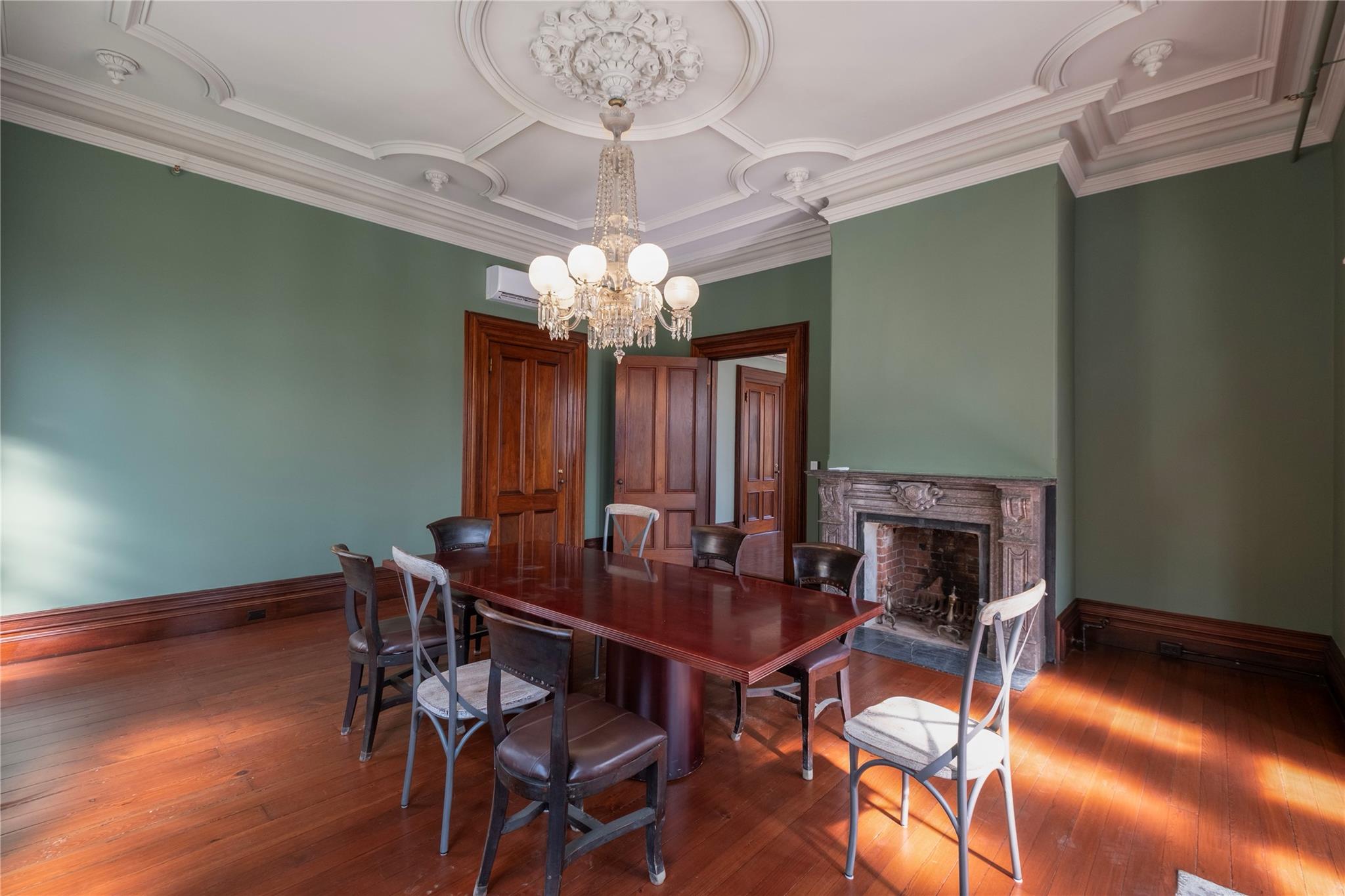 Dining space featuring a chandelier, a high end fireplace, and hardwood / wood-style floors