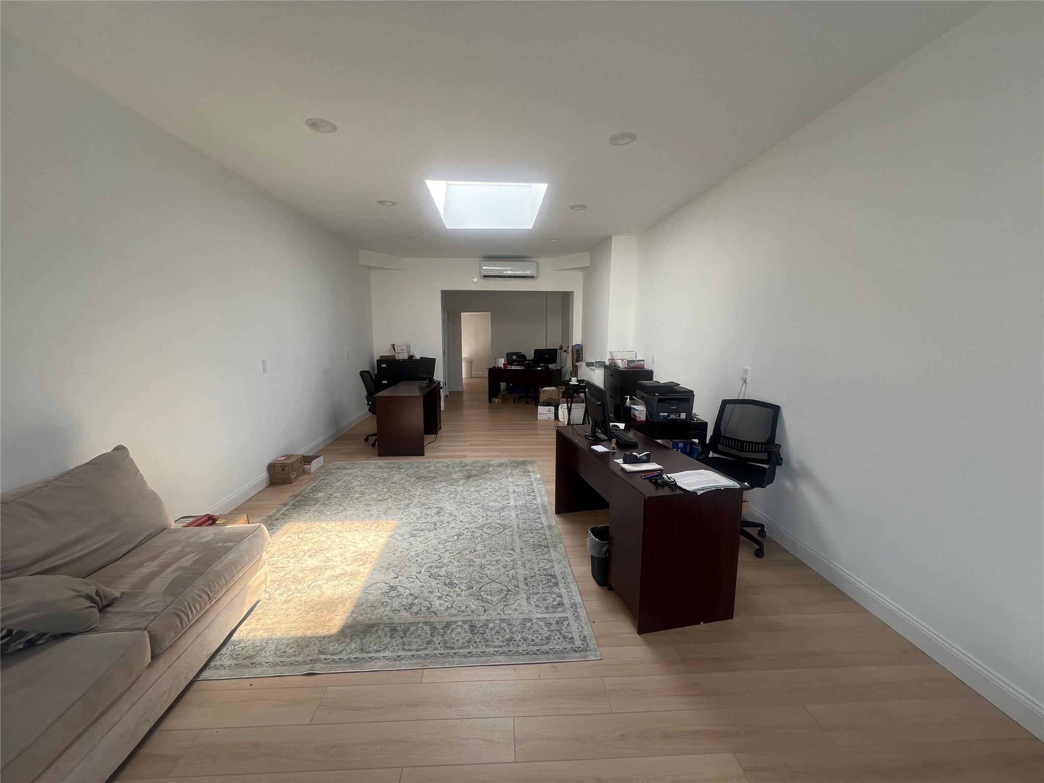 Office with a skylight and light wood-style flooring