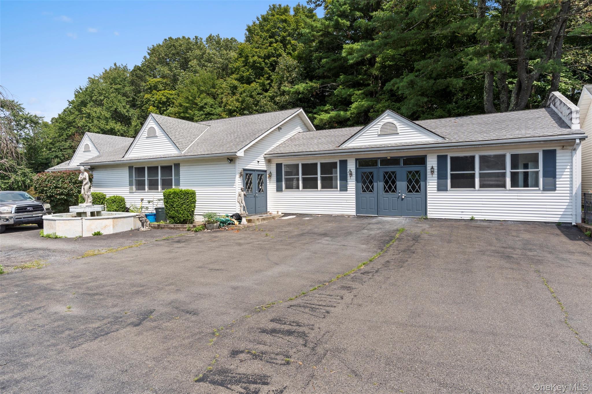Ranch-style house featuring roof with shingles and asphalt driveway