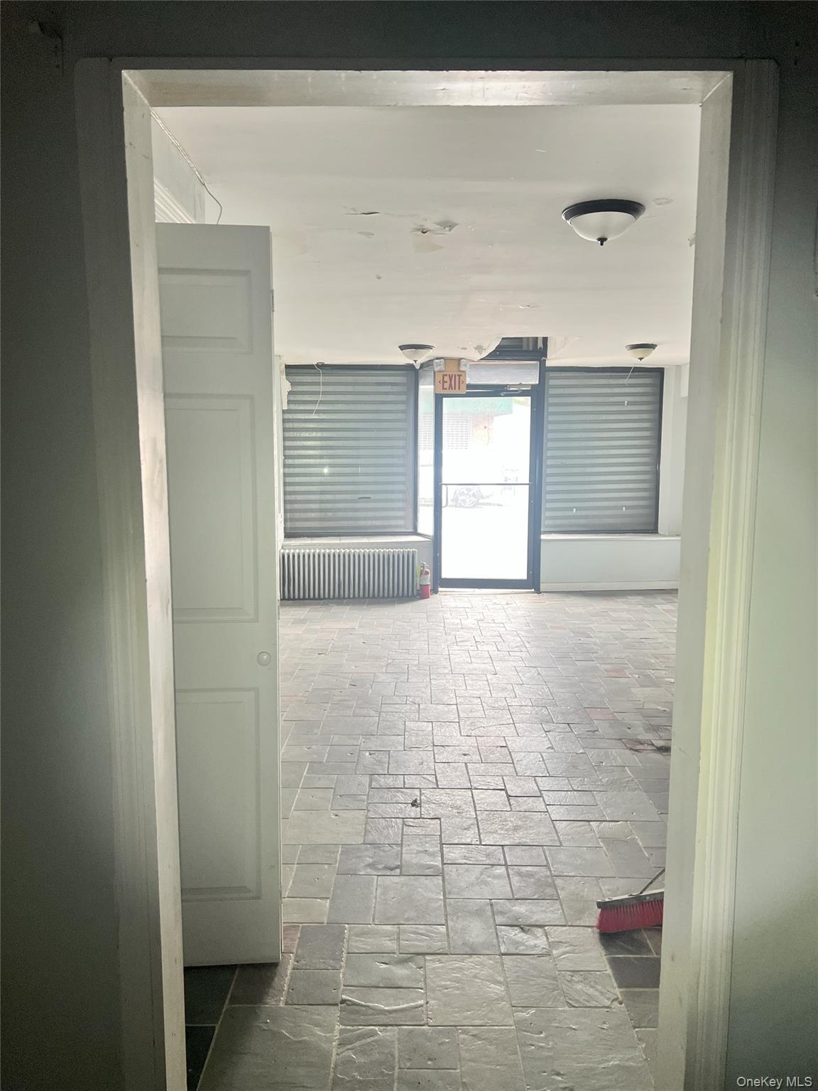 Corridor featuring stone tile flooring and radiator heating unit