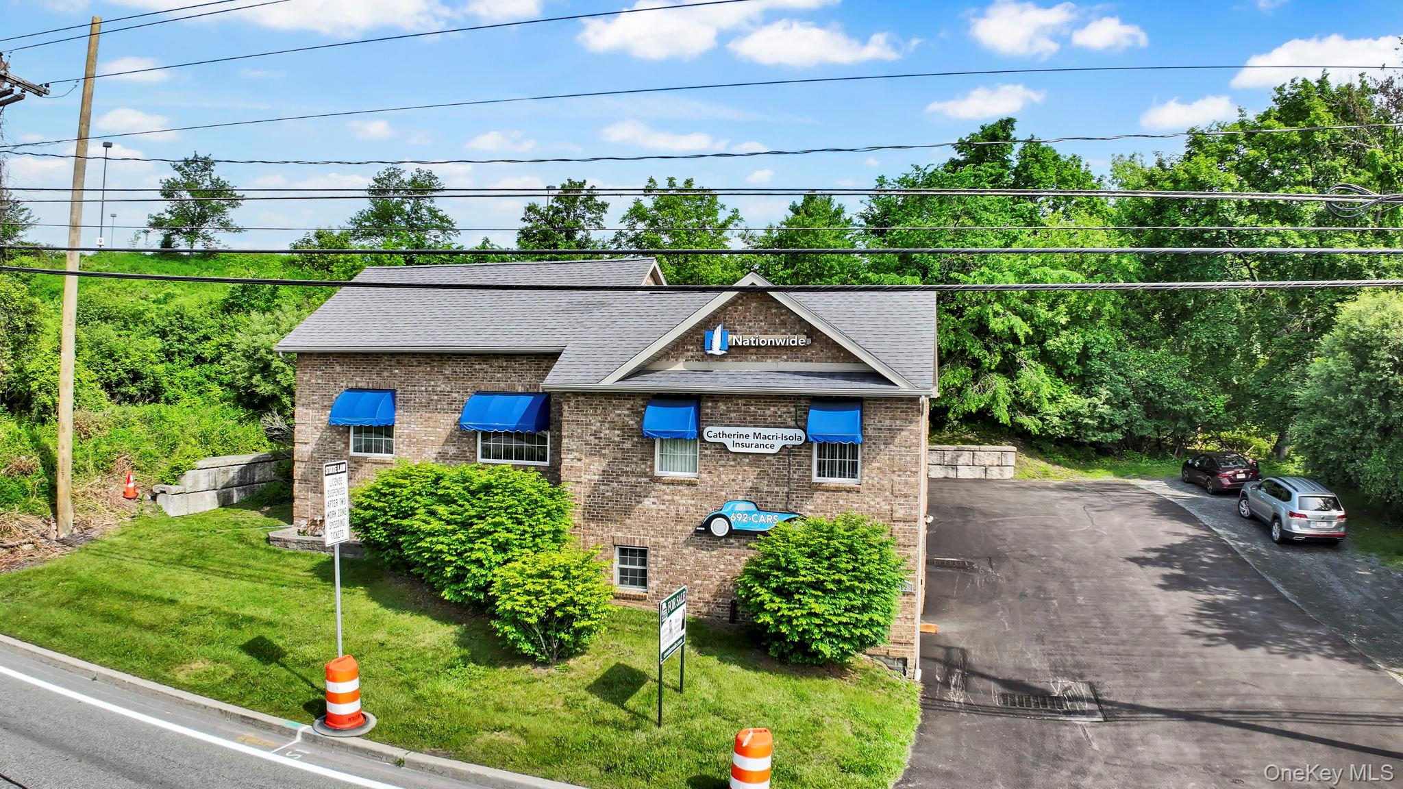 View of front of property featuring brick siding, roof with shingles, and a front yard