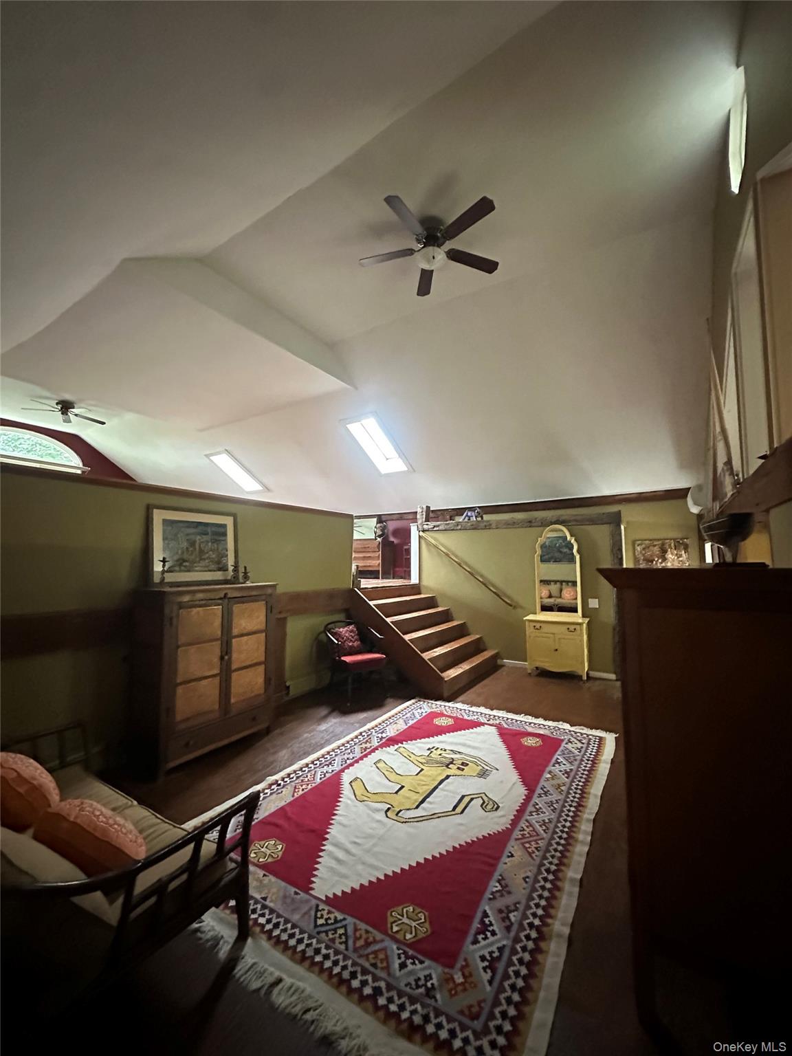 Bedroom featuring vaulted ceiling, wood finished floors, and a ceiling fan