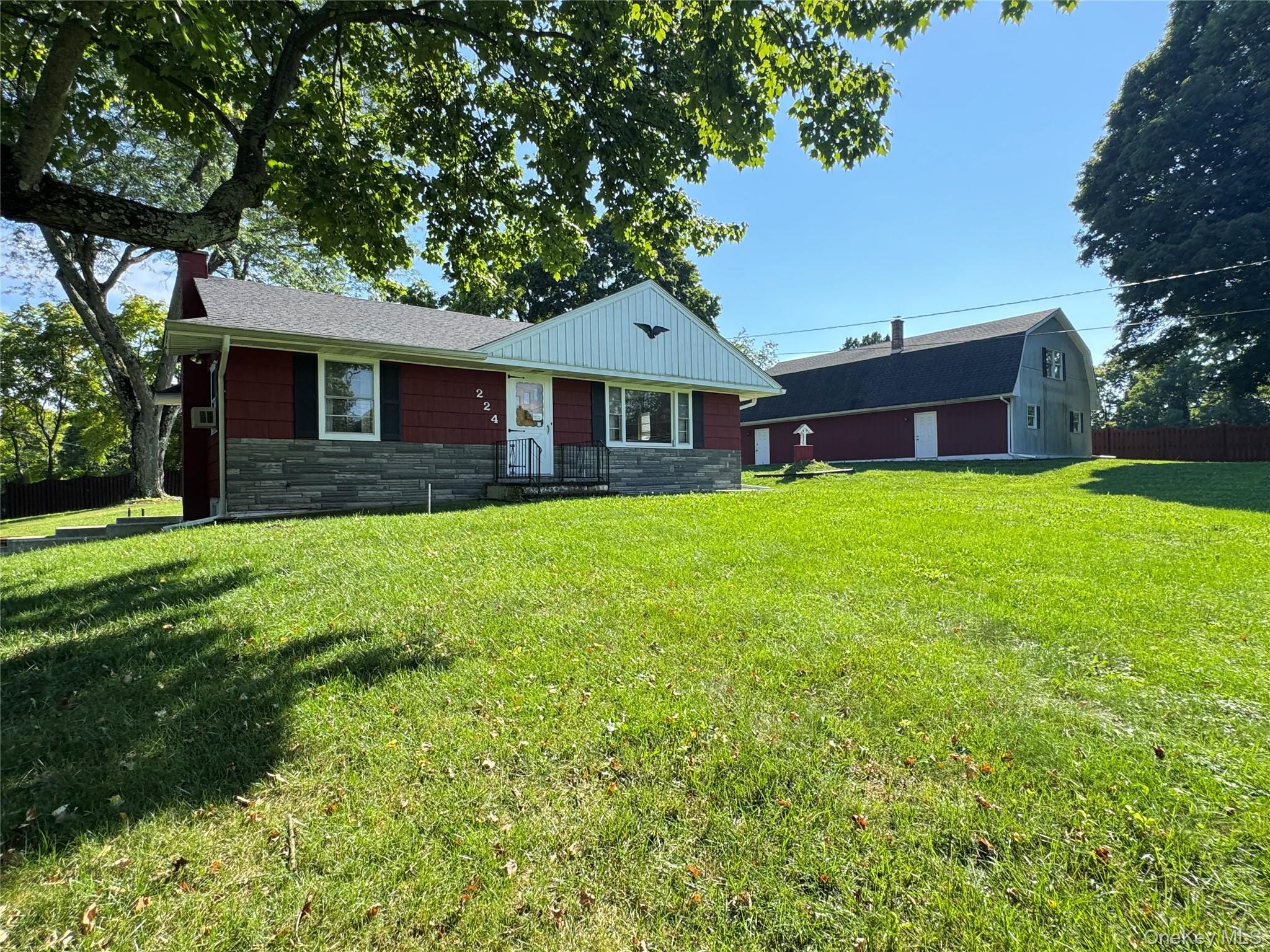 Ranch-style house with stone siding and a front lawn