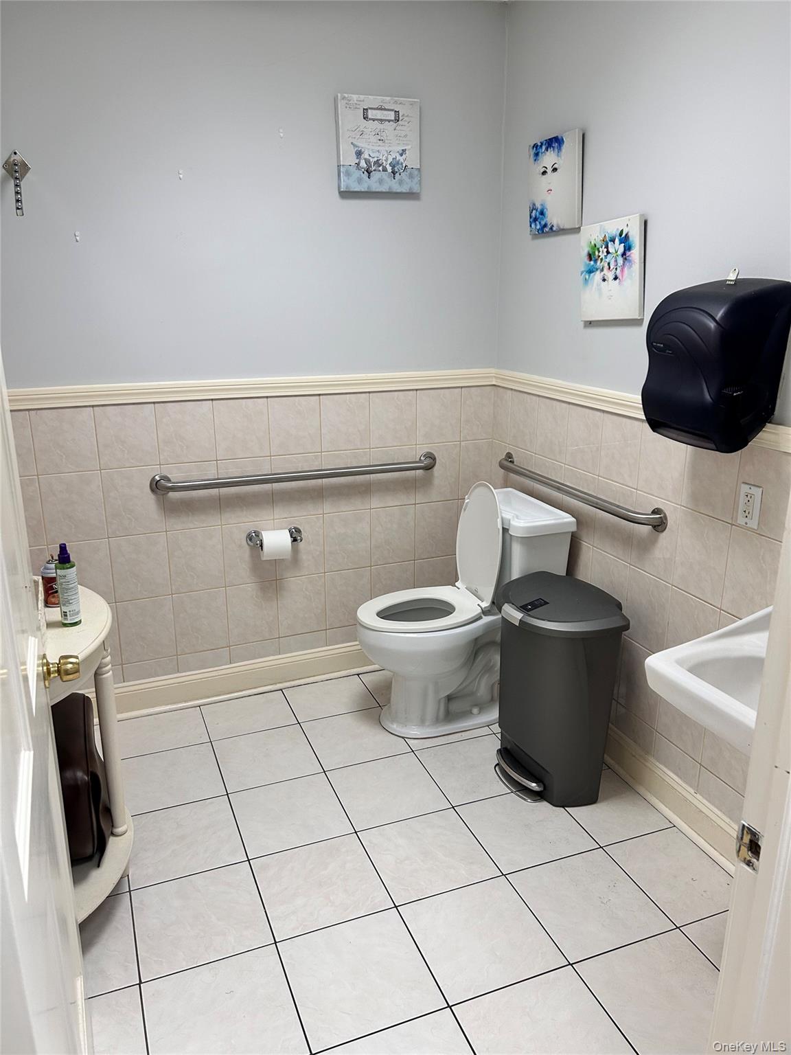 Bathroom featuring wainscoting, tile walls, and light tile patterned floors