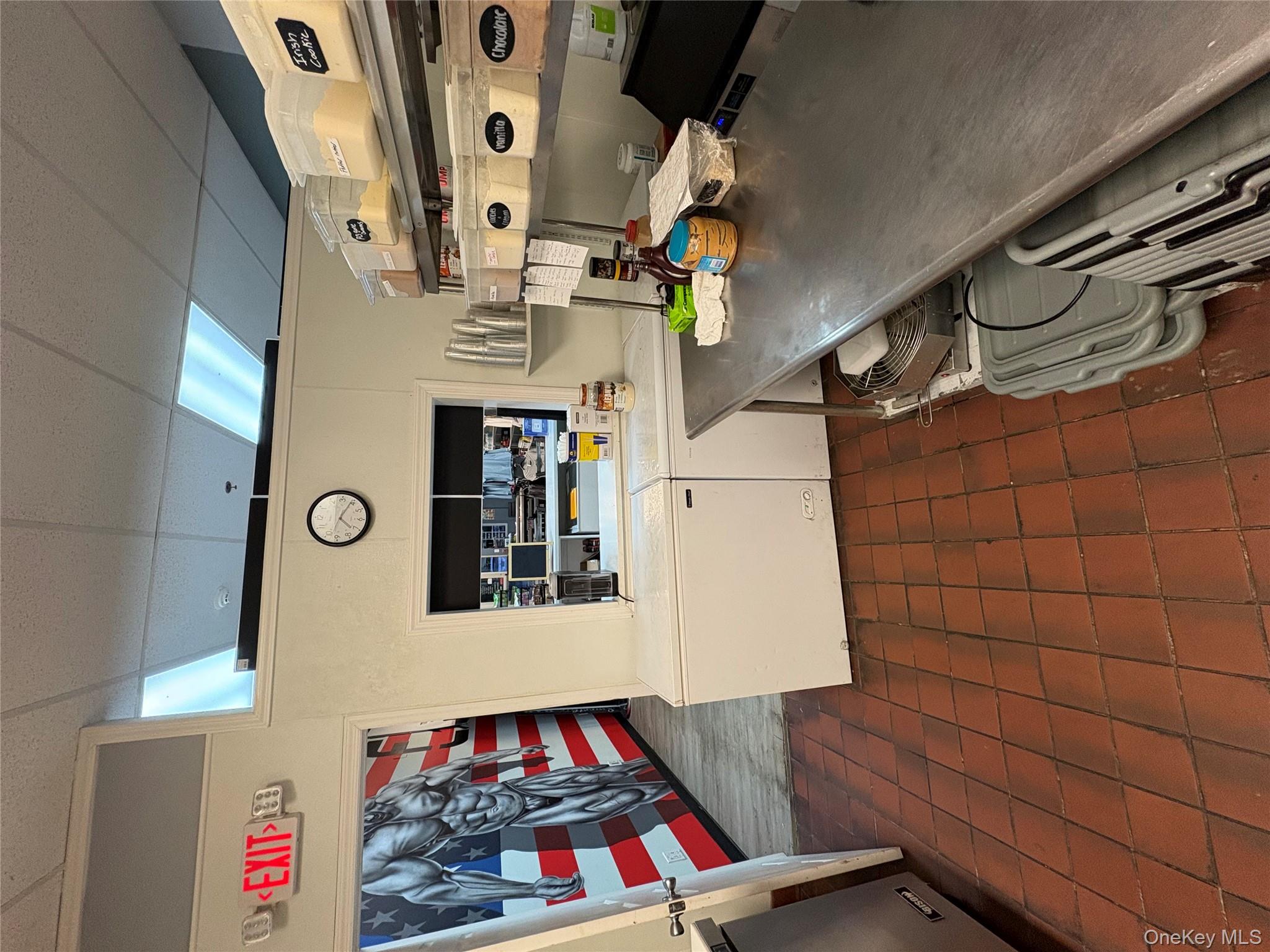 Kitchen featuring a drop ceiling, refrigerator, white cabinetry, and dark tile patterned flooring