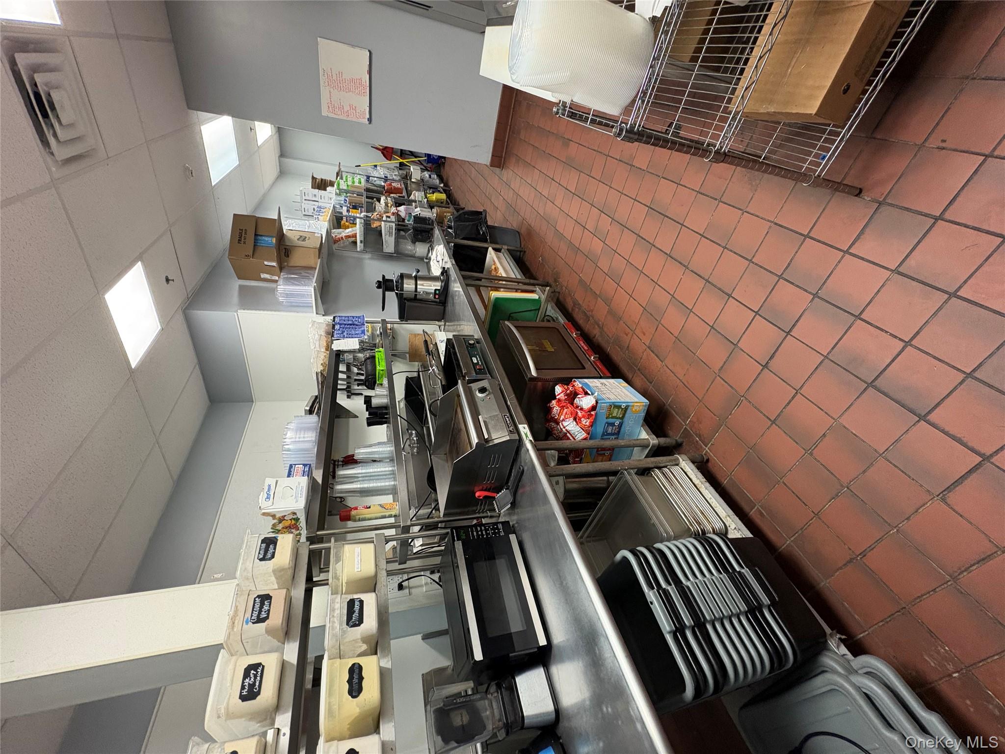Kitchen featuring a paneled ceiling, dark tile patterned floors, and open shelves