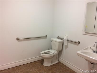 Half bathroom featuring toilet and baseboards