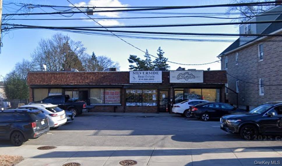 View of commercial property featuring uncovered parking