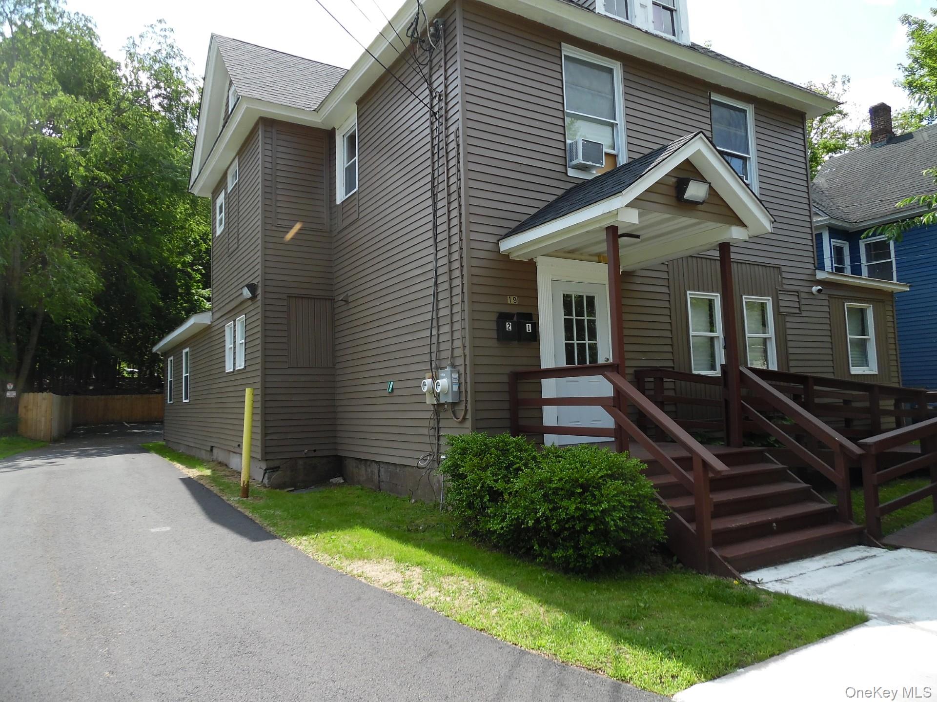 American foursquare style home with roof with shingles