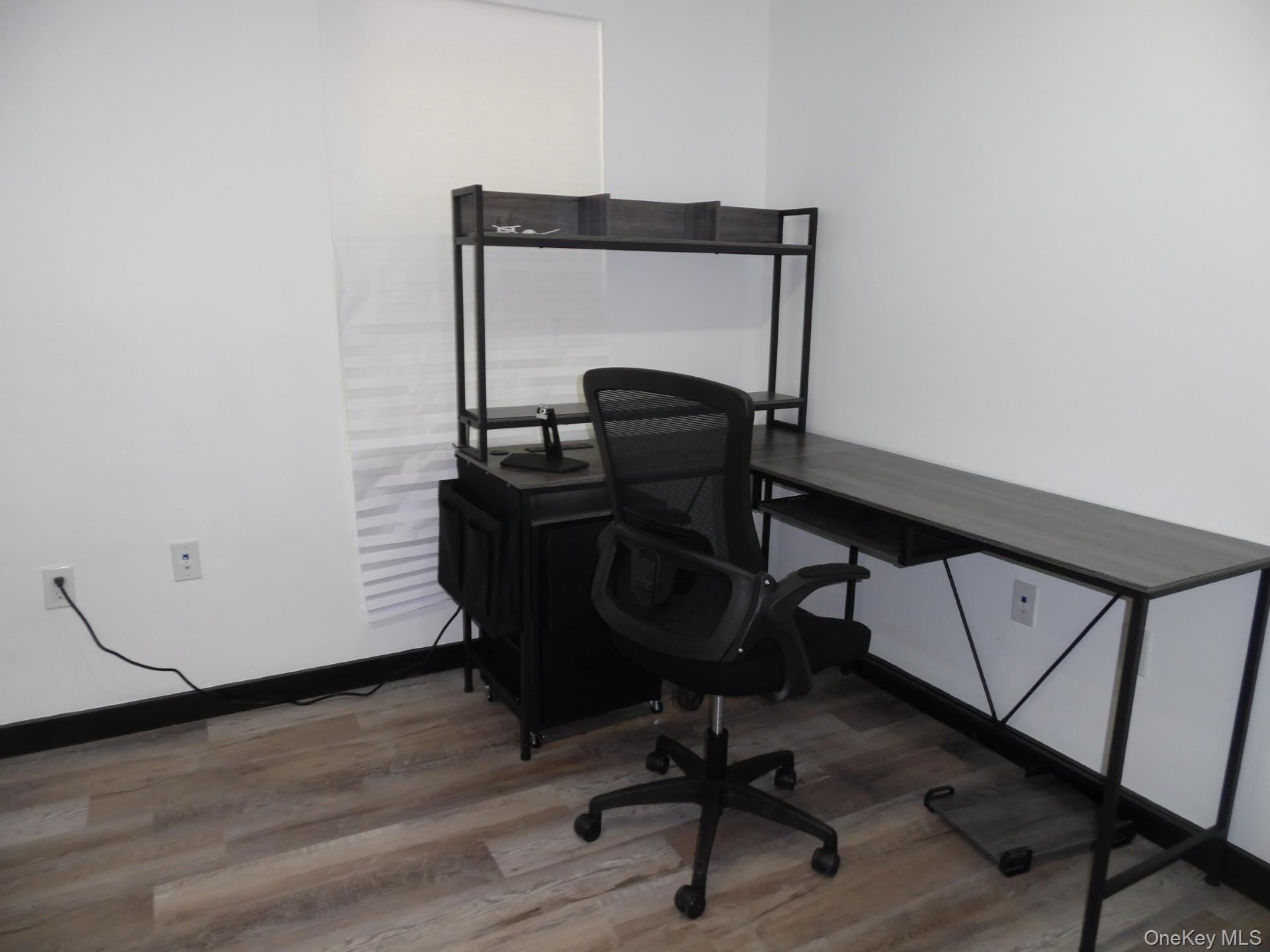 Office area featuring light wood-style floors and baseboards