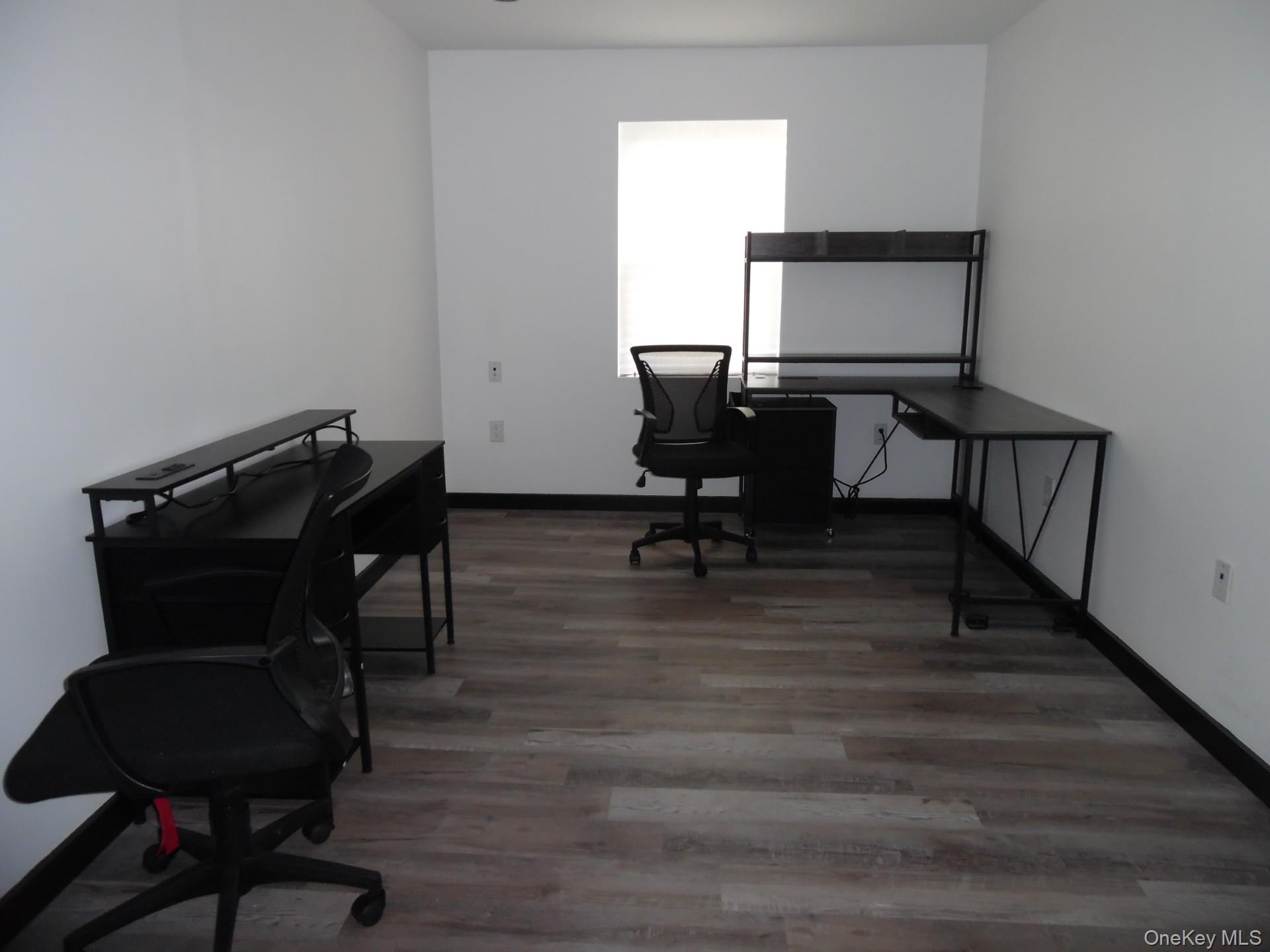 Office space with light wood-style floors and baseboards