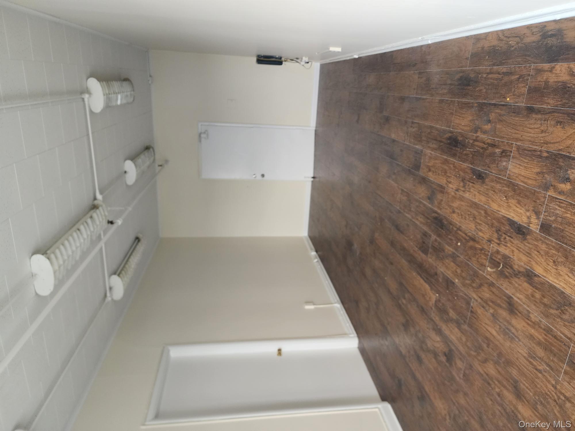 Empty room with dark wood-type flooring and baseboards