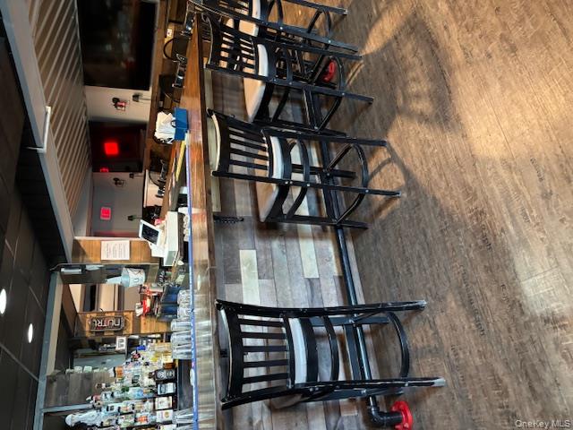 Indoor dry bar featuring dark wood finished floors