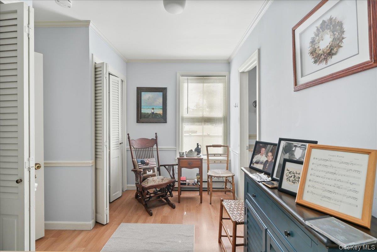 Living area with light wood-style flooring and crown molding