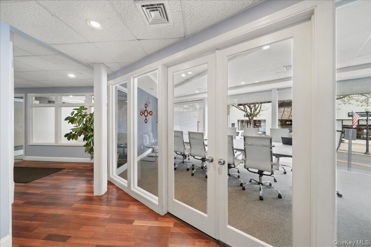 Exercise room with a drop ceiling, recessed lighting, and dark wood-style floors