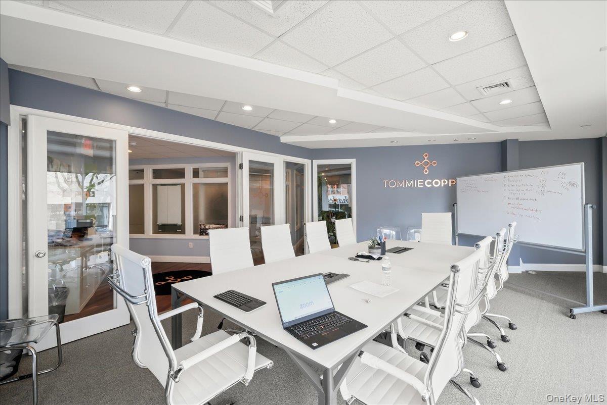 Carpeted office space featuring a drop ceiling and recessed lighting