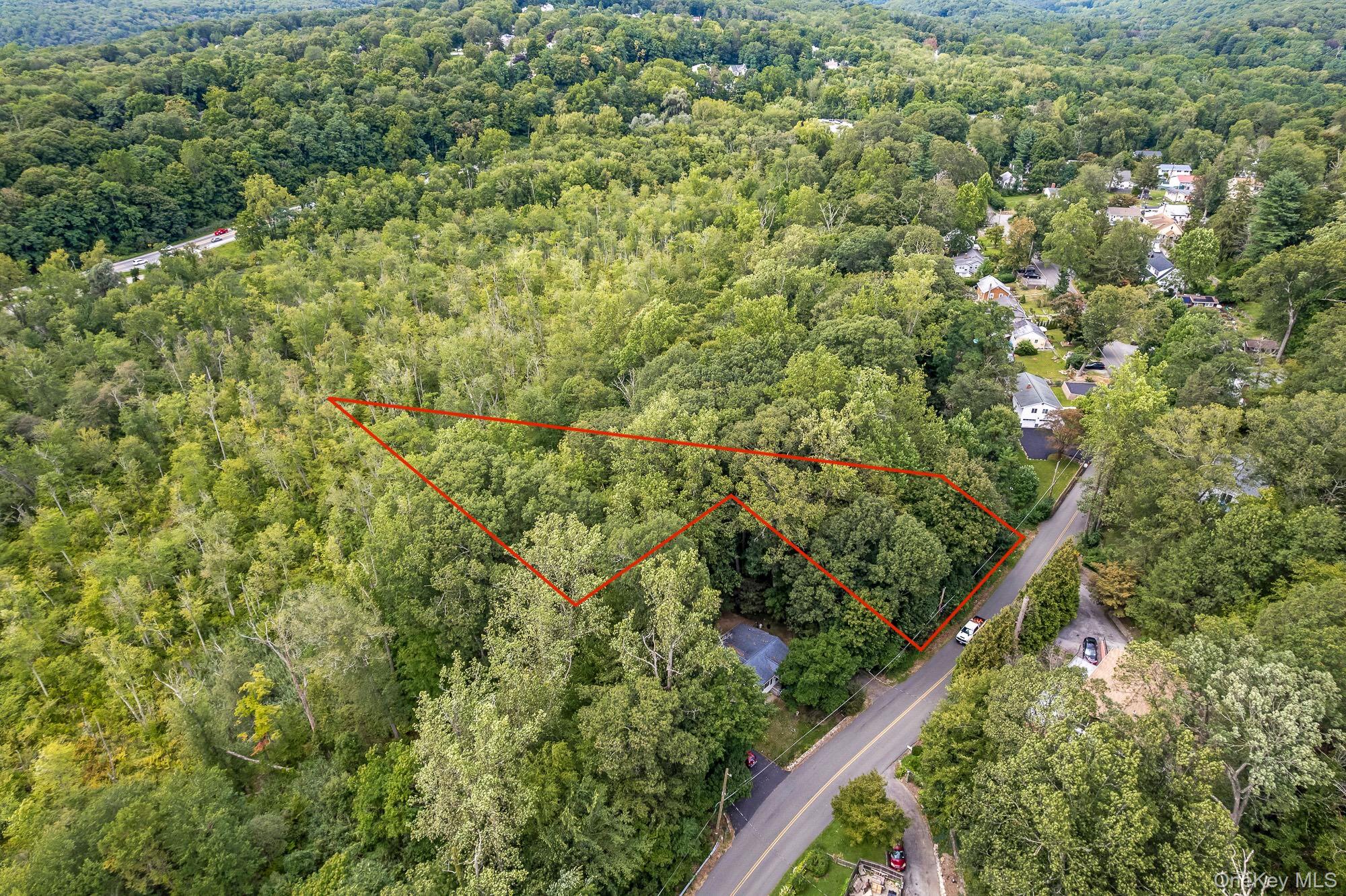 Aerial overview of property's location featuring a heavily wooded area and property parcel outlined