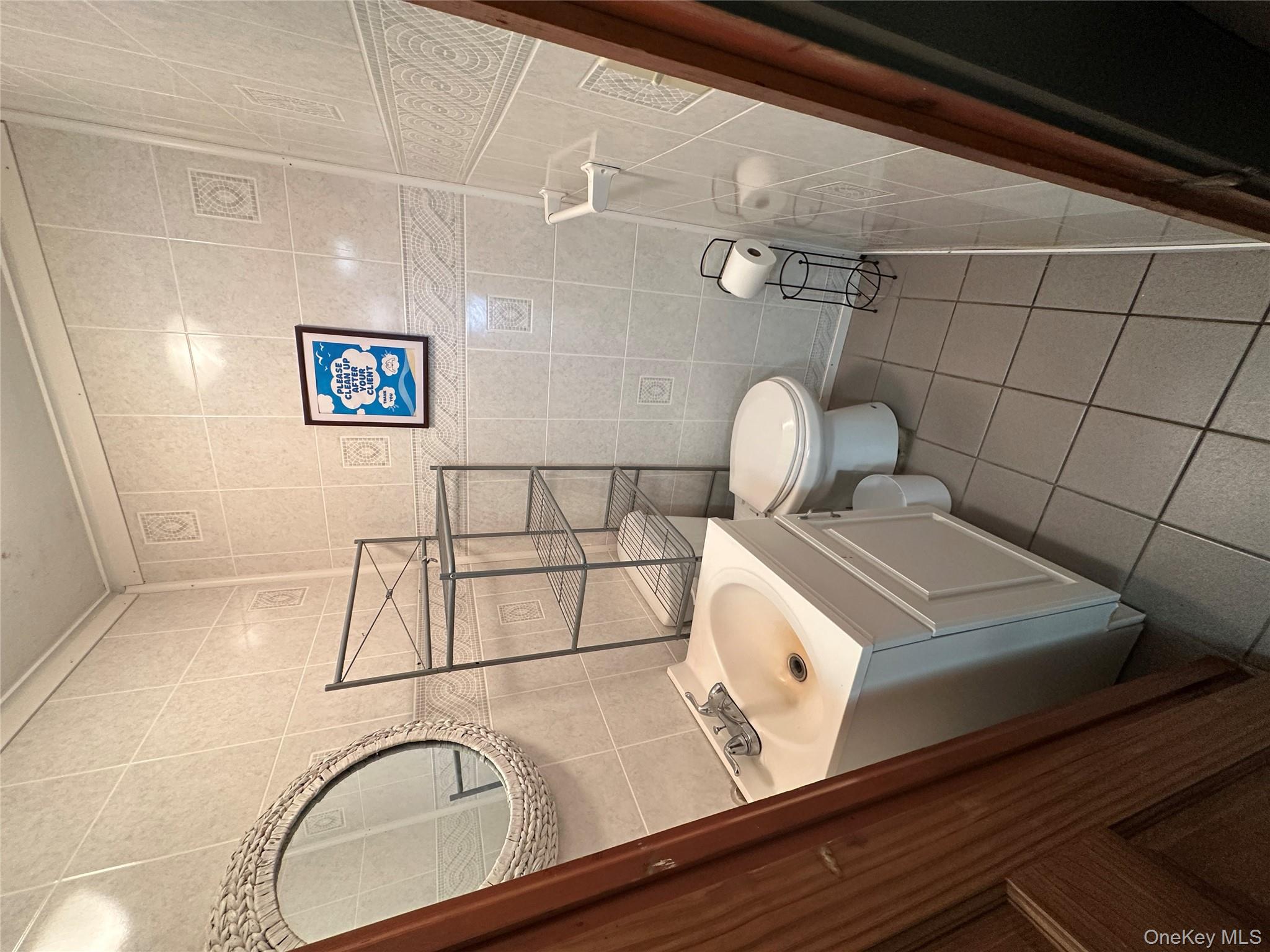 Half bathroom featuring tile walls, tile patterned floors, and vanity