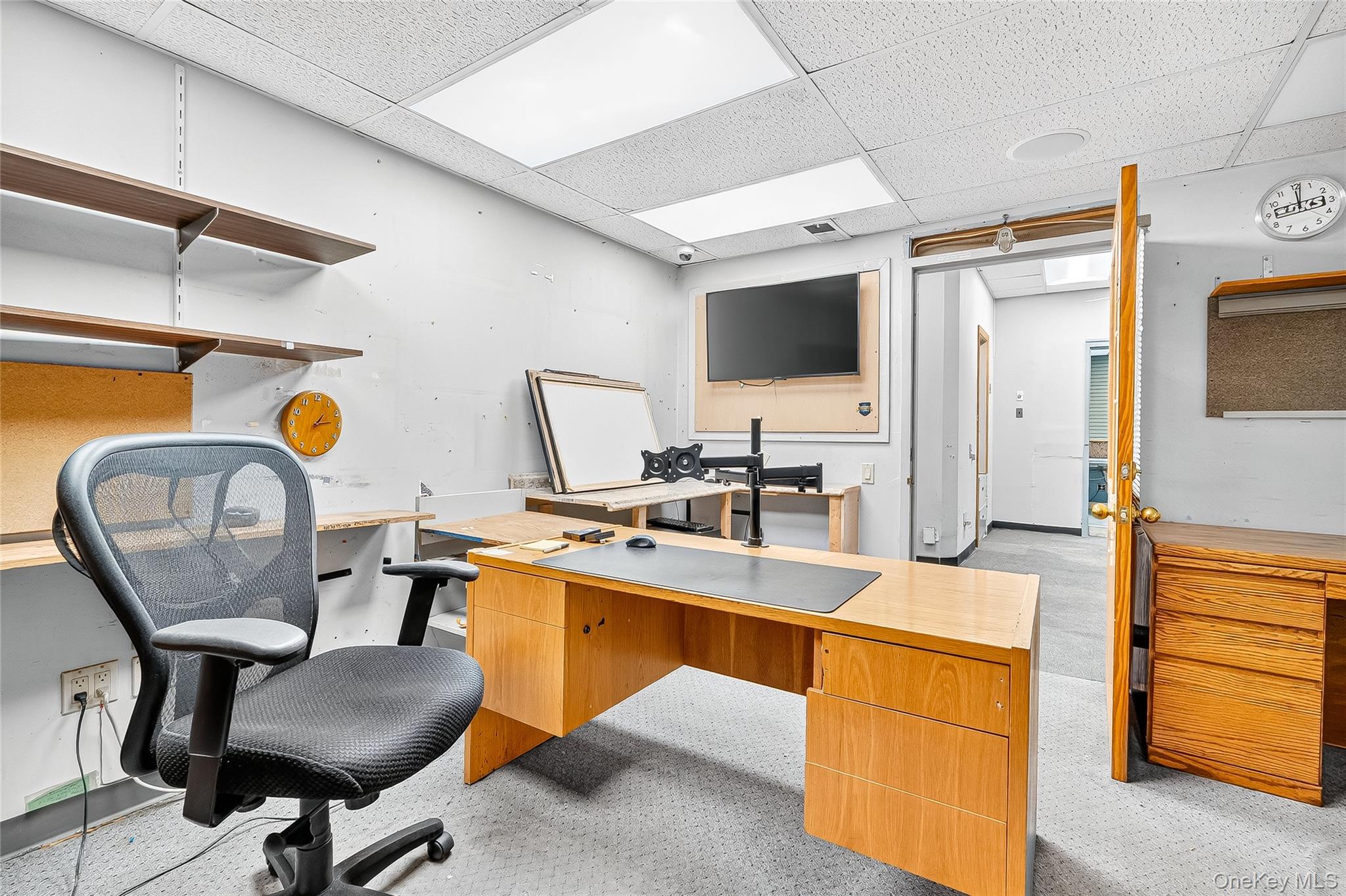 Office area featuring a drop ceiling and light carpet