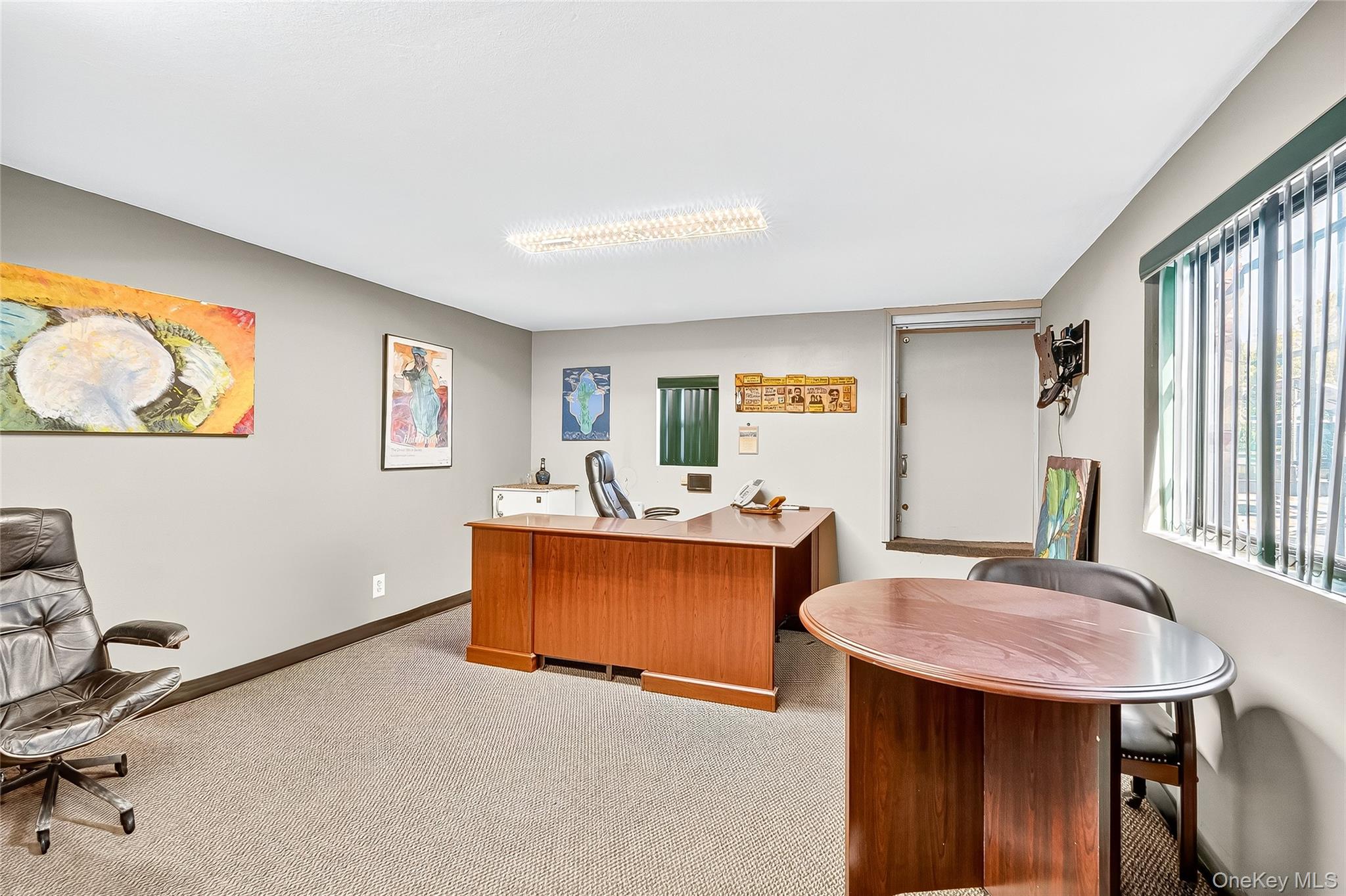 Home office with baseboards and light carpet